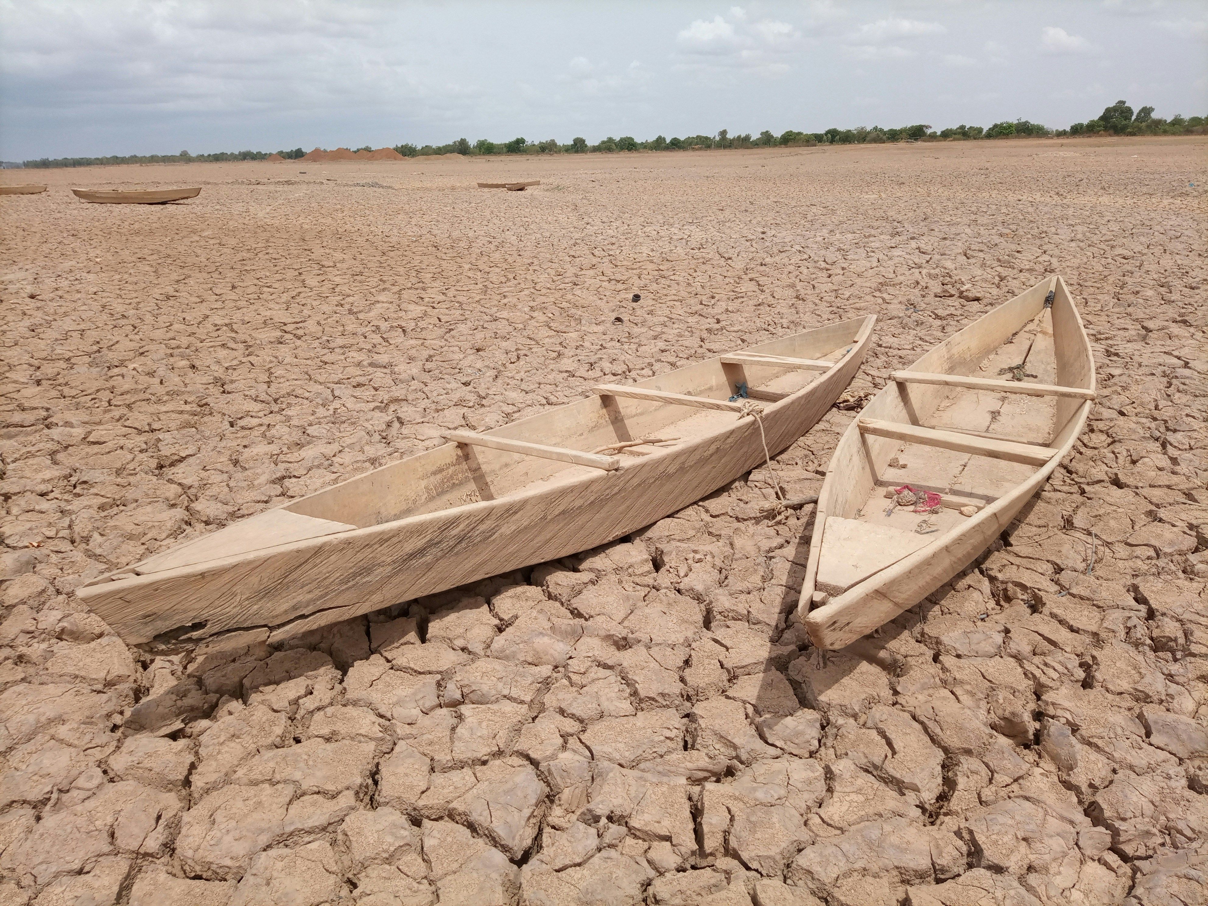Two boats sit on very dried land