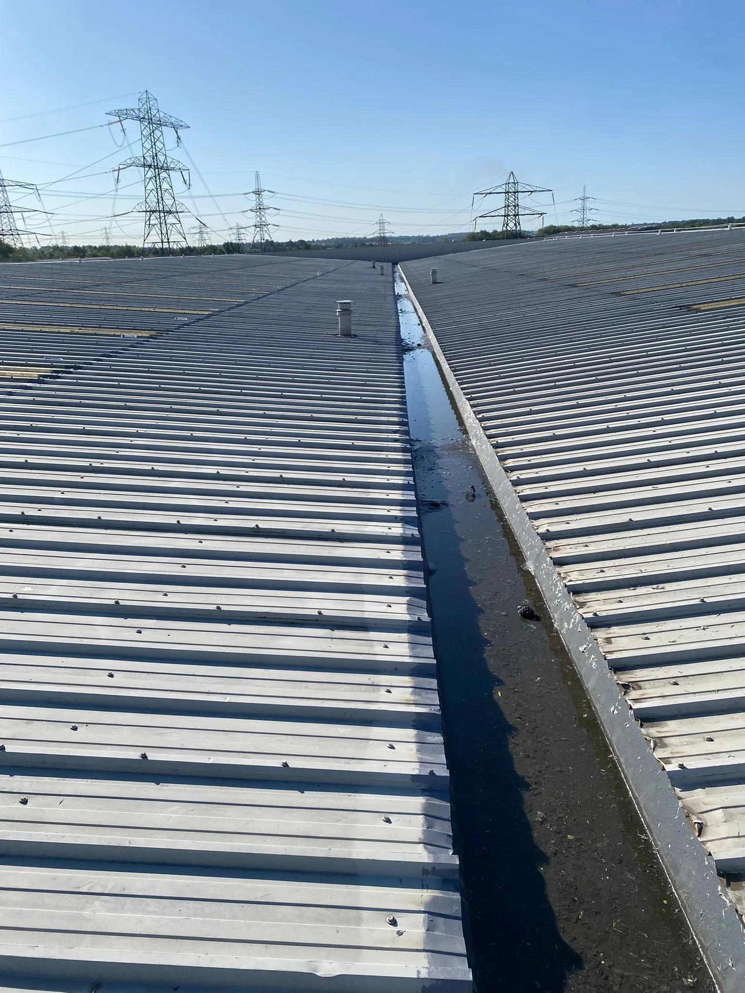 Standing water and debris lying in the sole of a box gutter