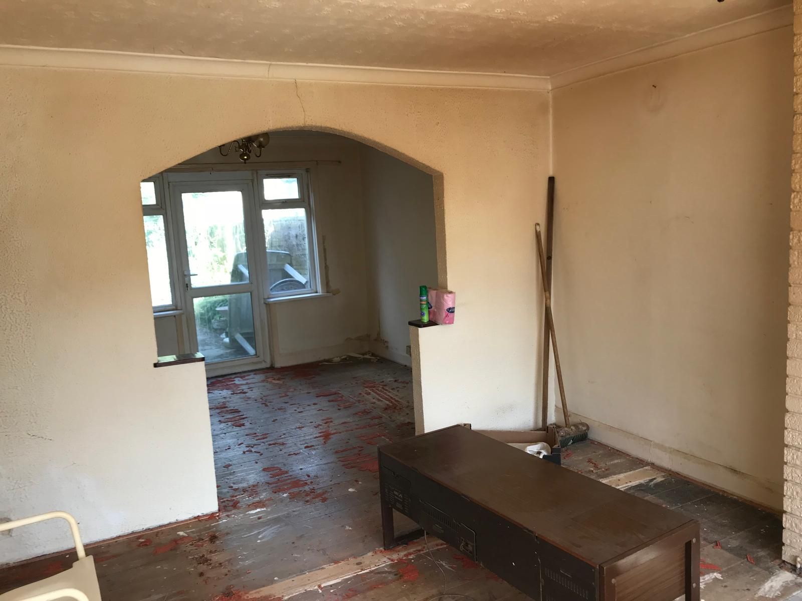 Before refurbishment: stripped living rooms with bare floors and unfinished walls