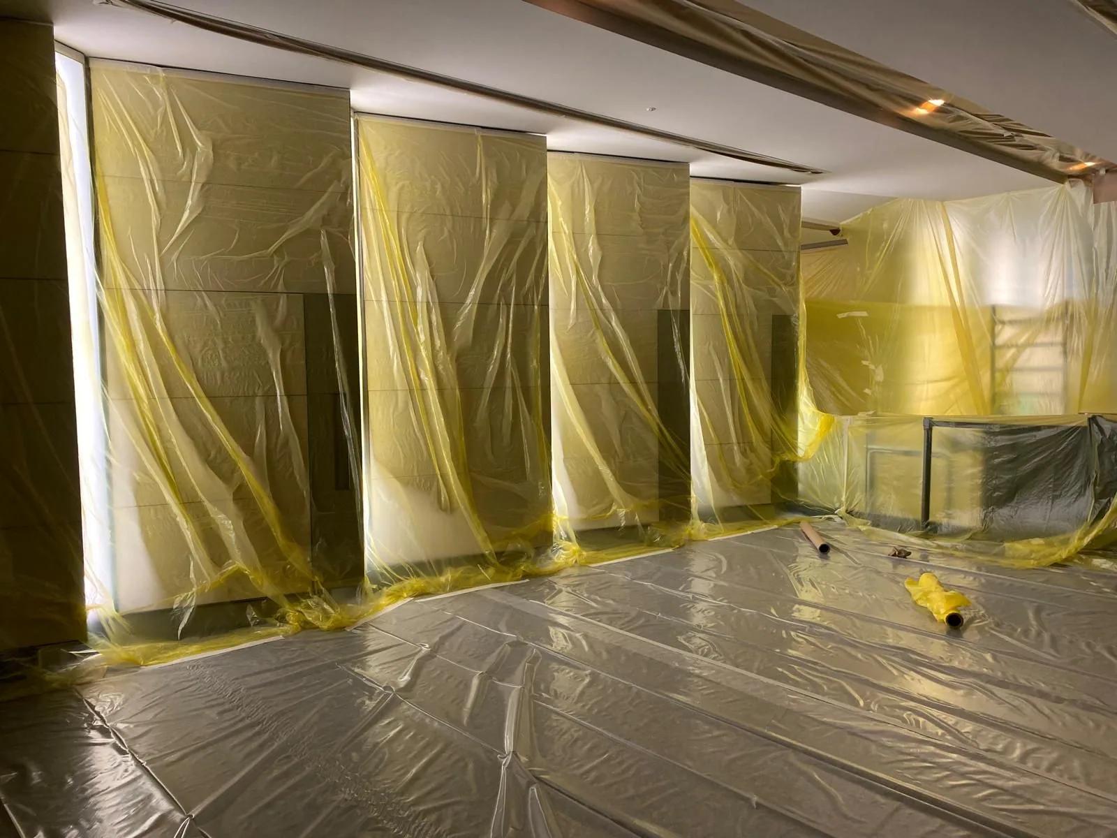 A marble lobby fully sheeted in protective film and floor covering before redecoration