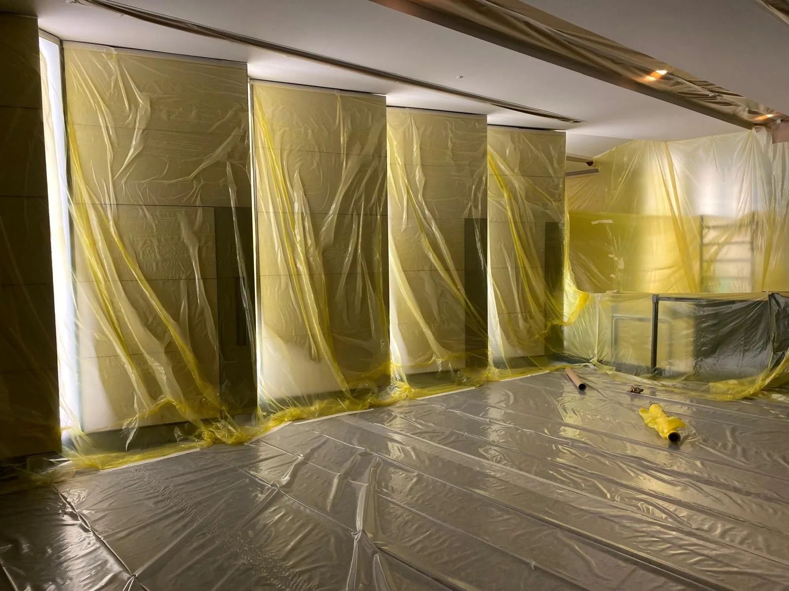 A marble lobby fully sheeted in protective film and floor covering before redecoration