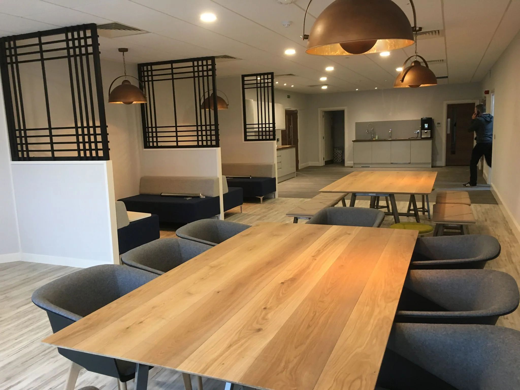 Refurbished commercial breakout space with fitted seating and timber tables
