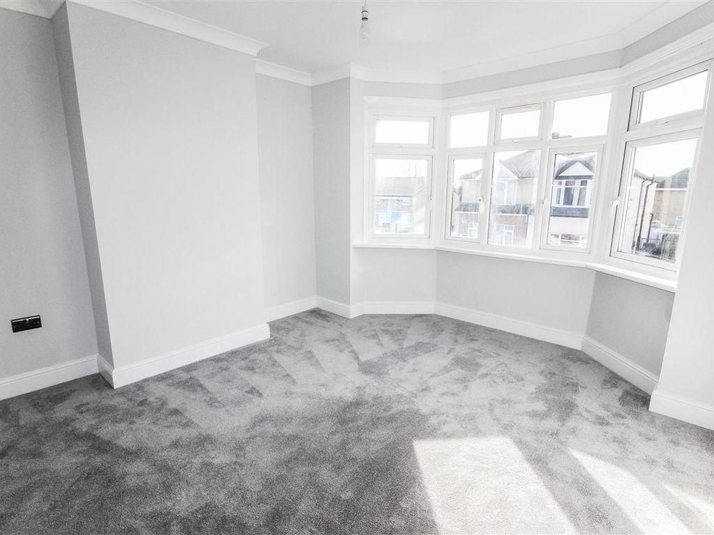 Refurbished bedroom with a bay window, white walls and grey carpet