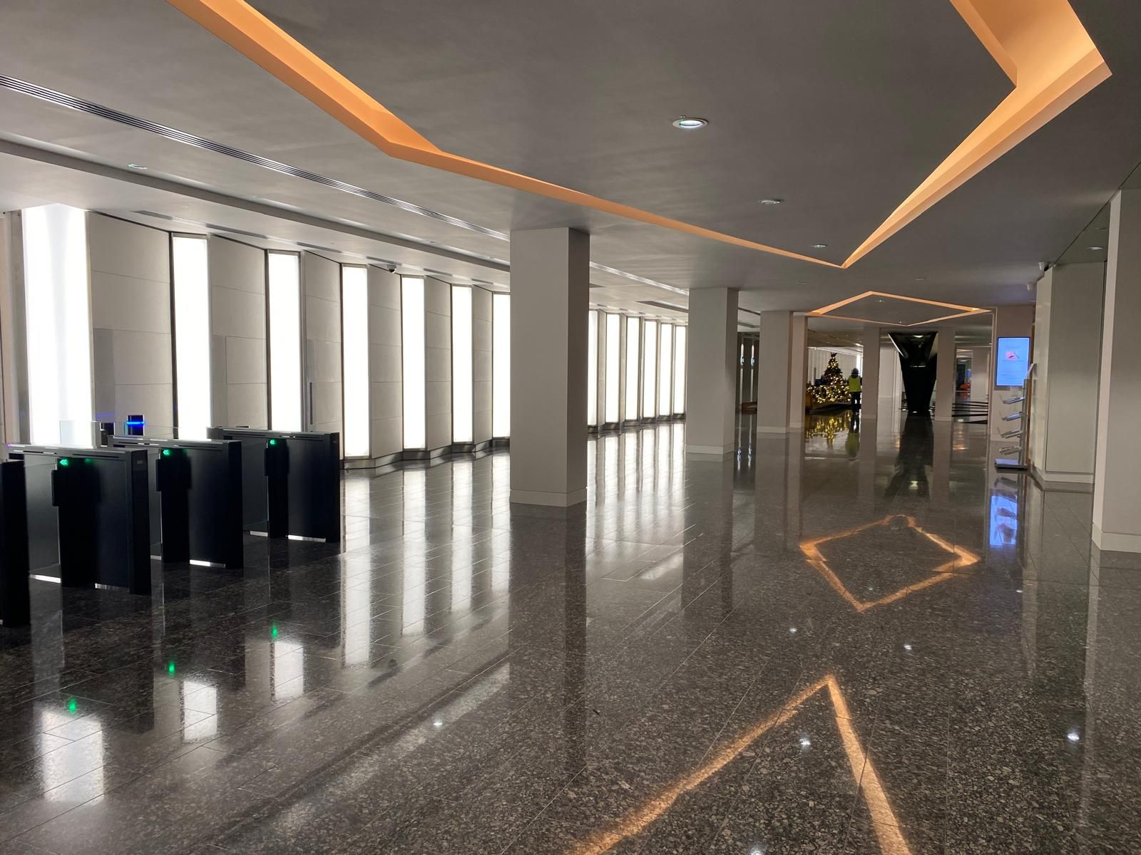 Office atrium after redecoration, with a lit ceiling coffer reflected in the polished granite floor