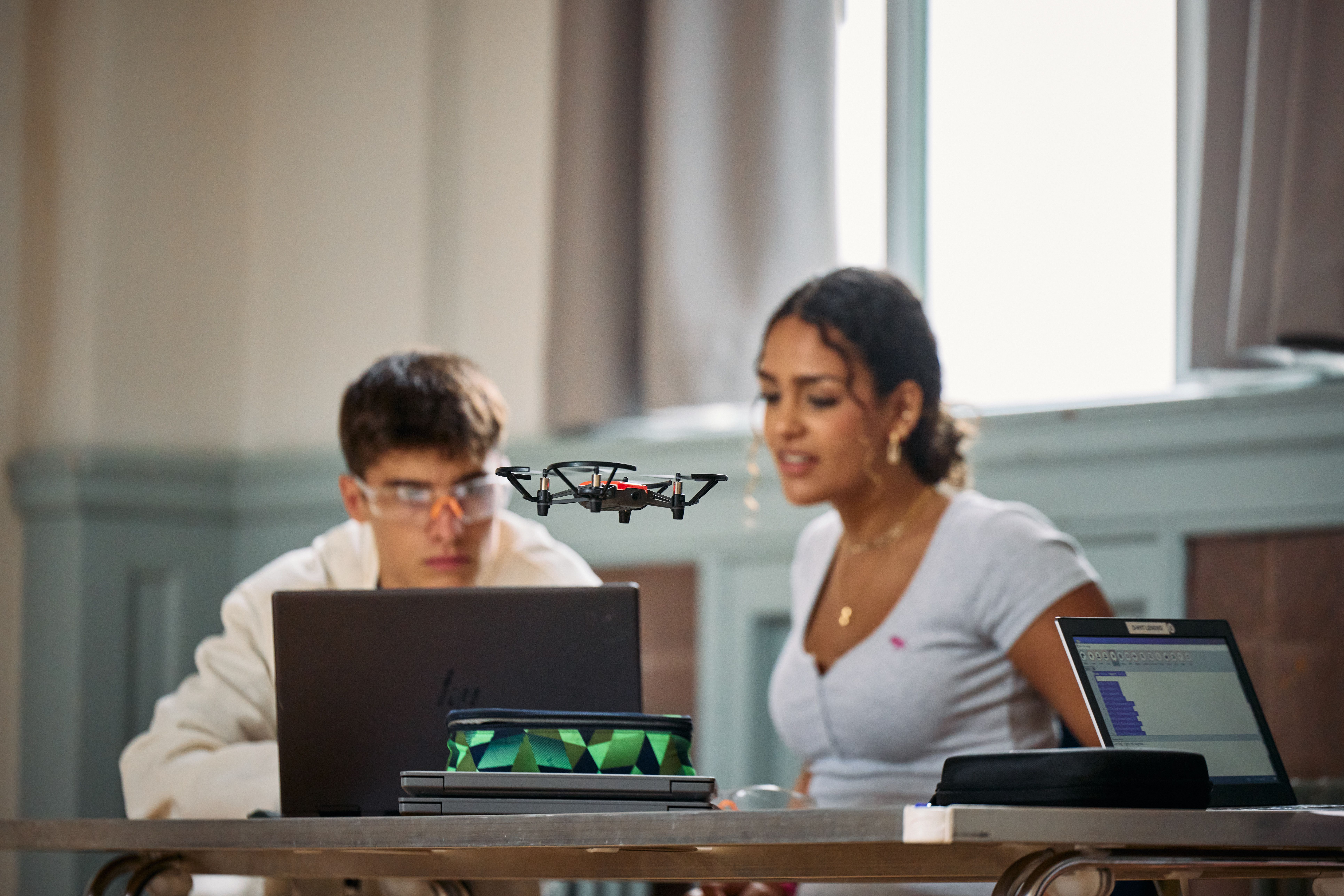 Two students flying a drone