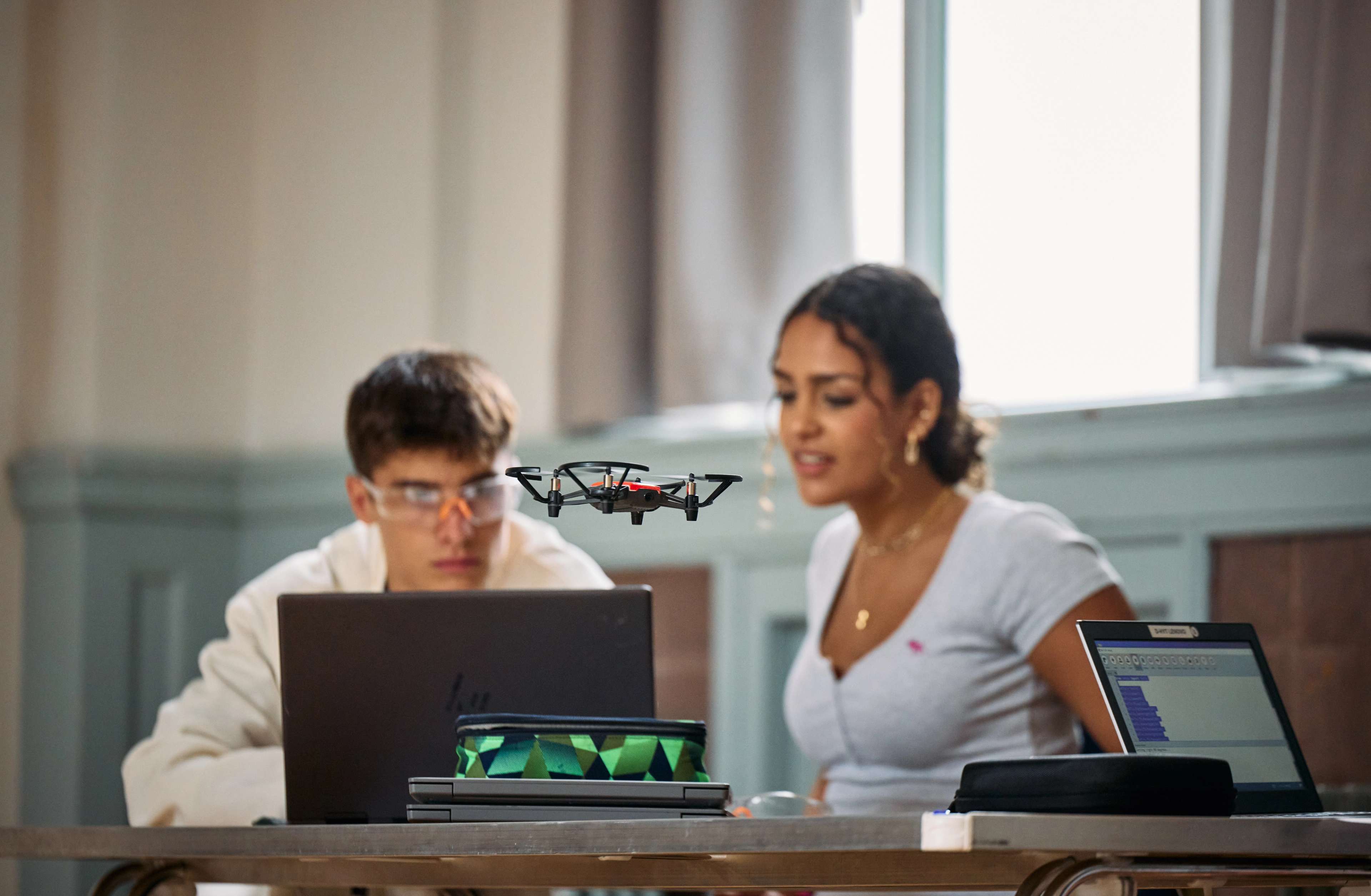Two students flying a drone