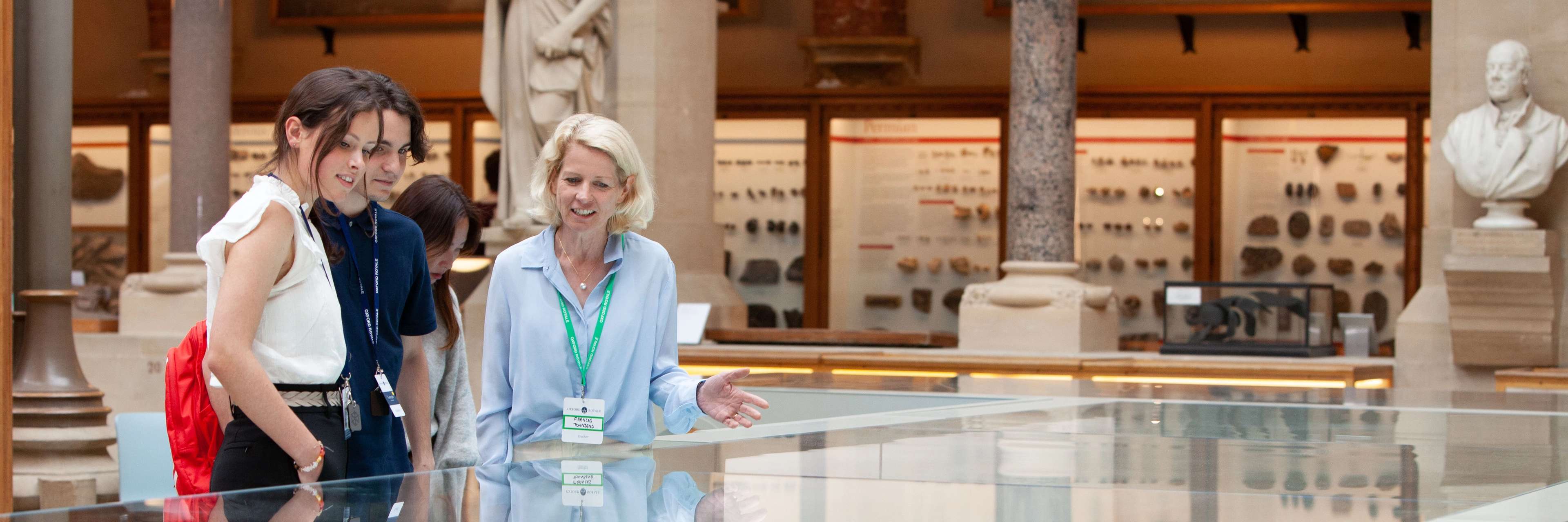 Students looking at museum artefacts with a teacher