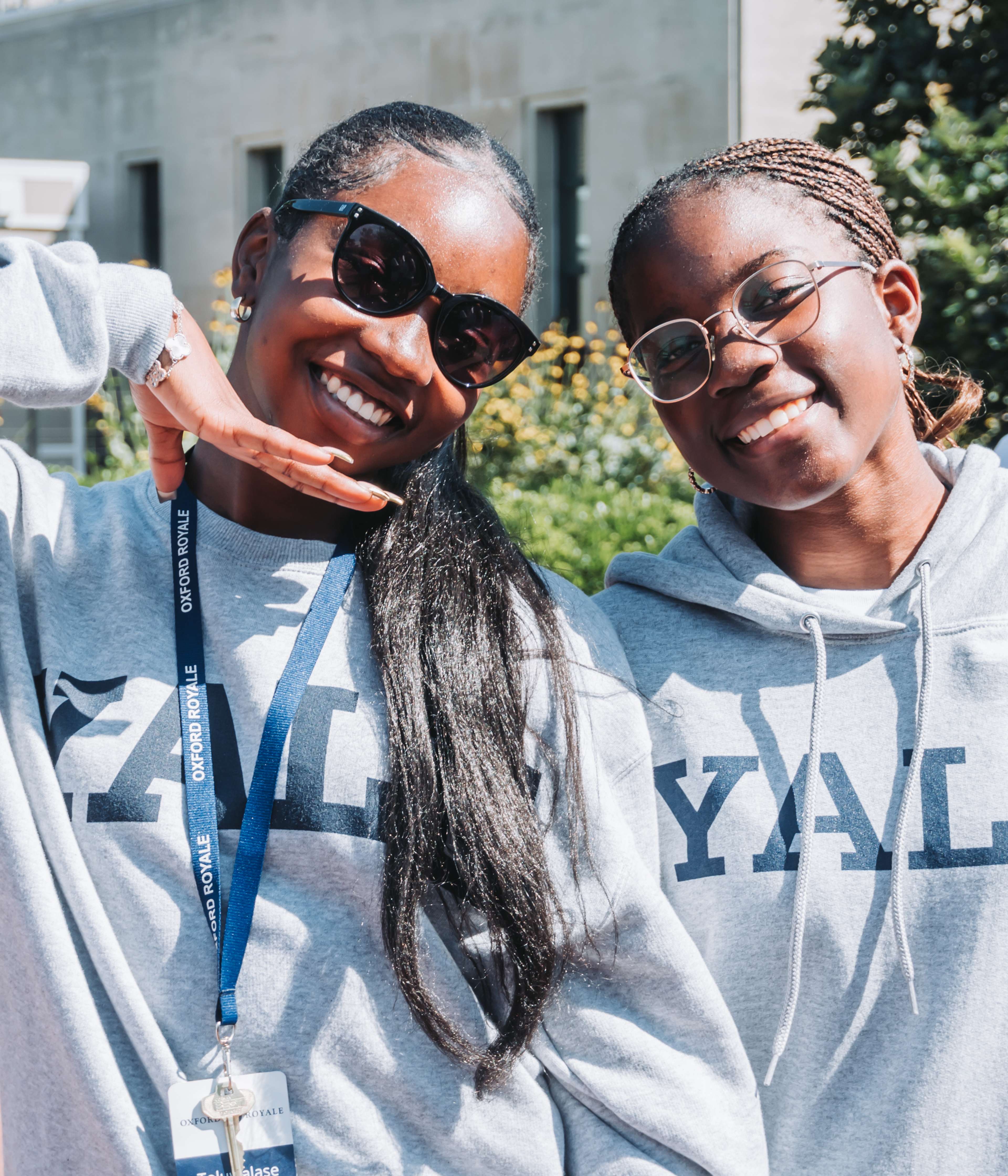 Two students smiling at the camera wearing Yale sweatshirts