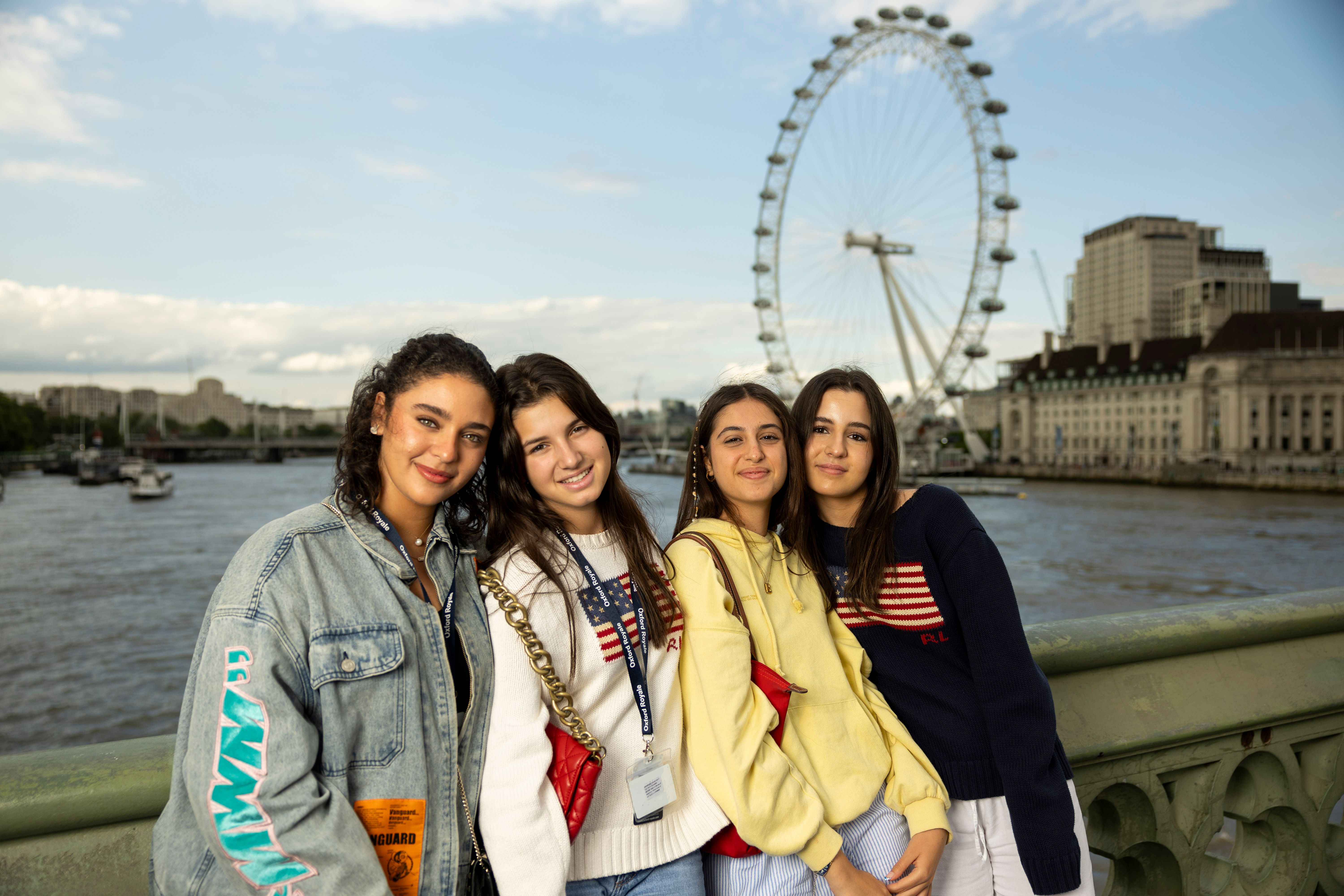 Group of students smiling in front of the London Eye