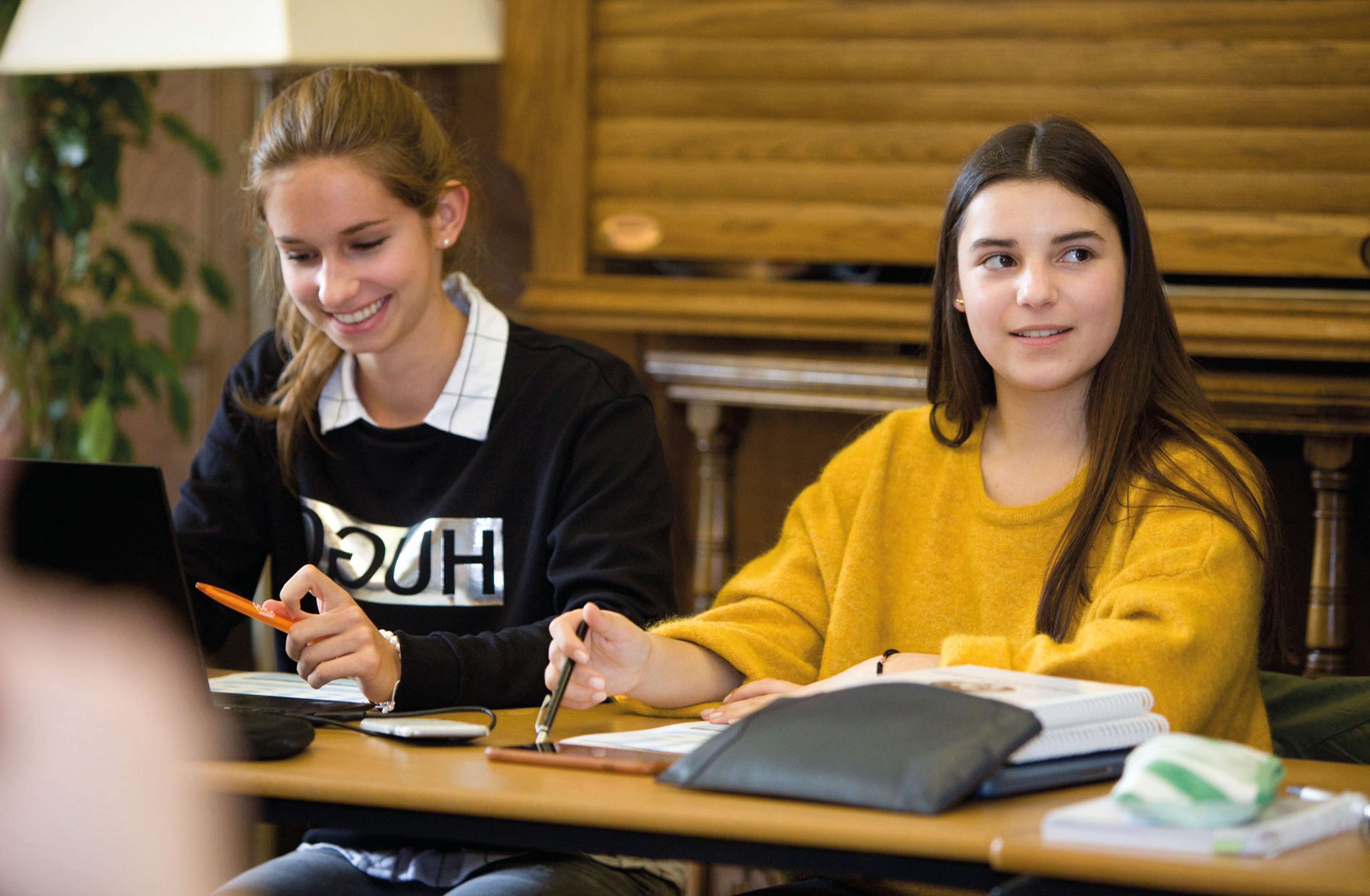 Two students listening at a desk