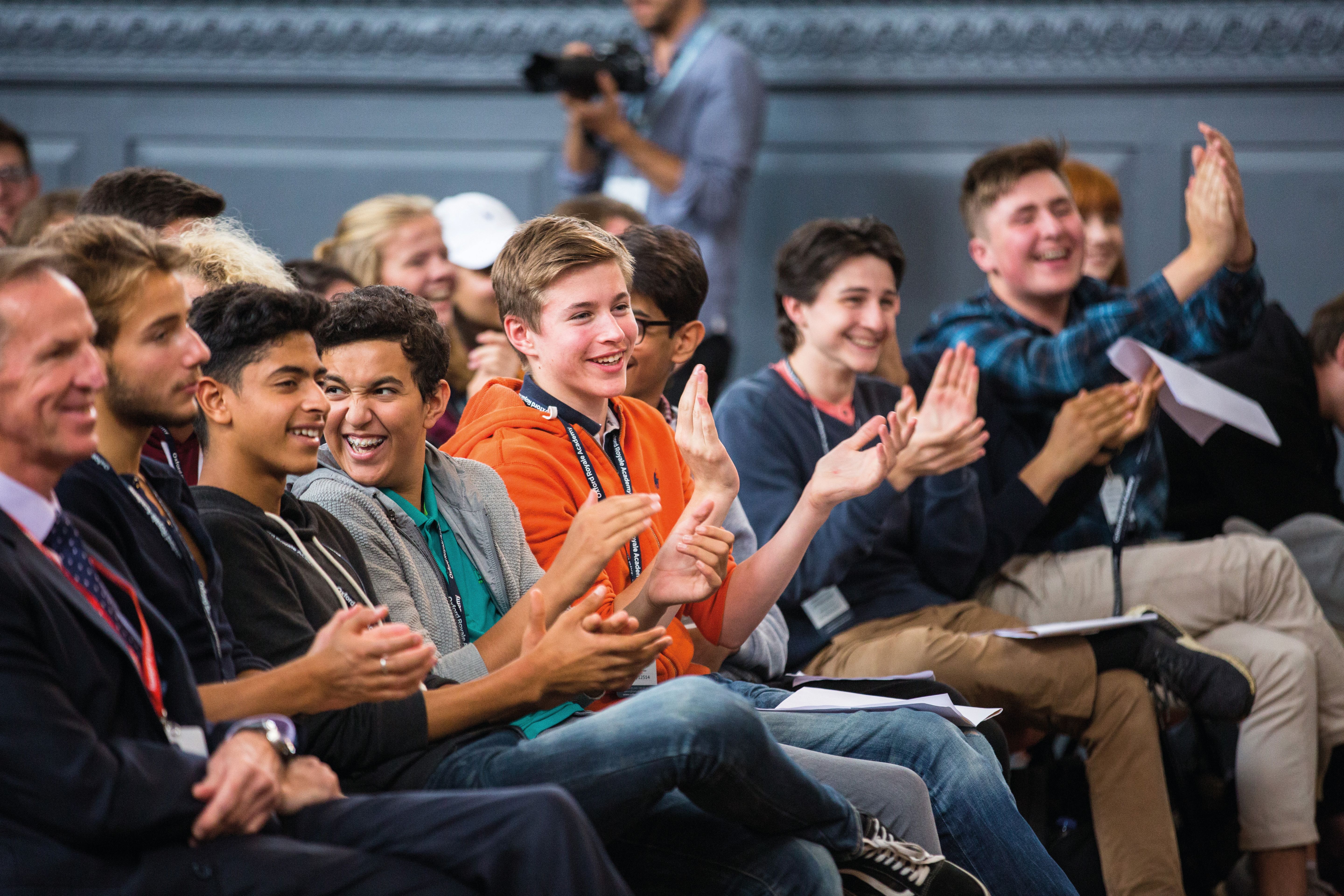 Students clapping while listening to a speaker