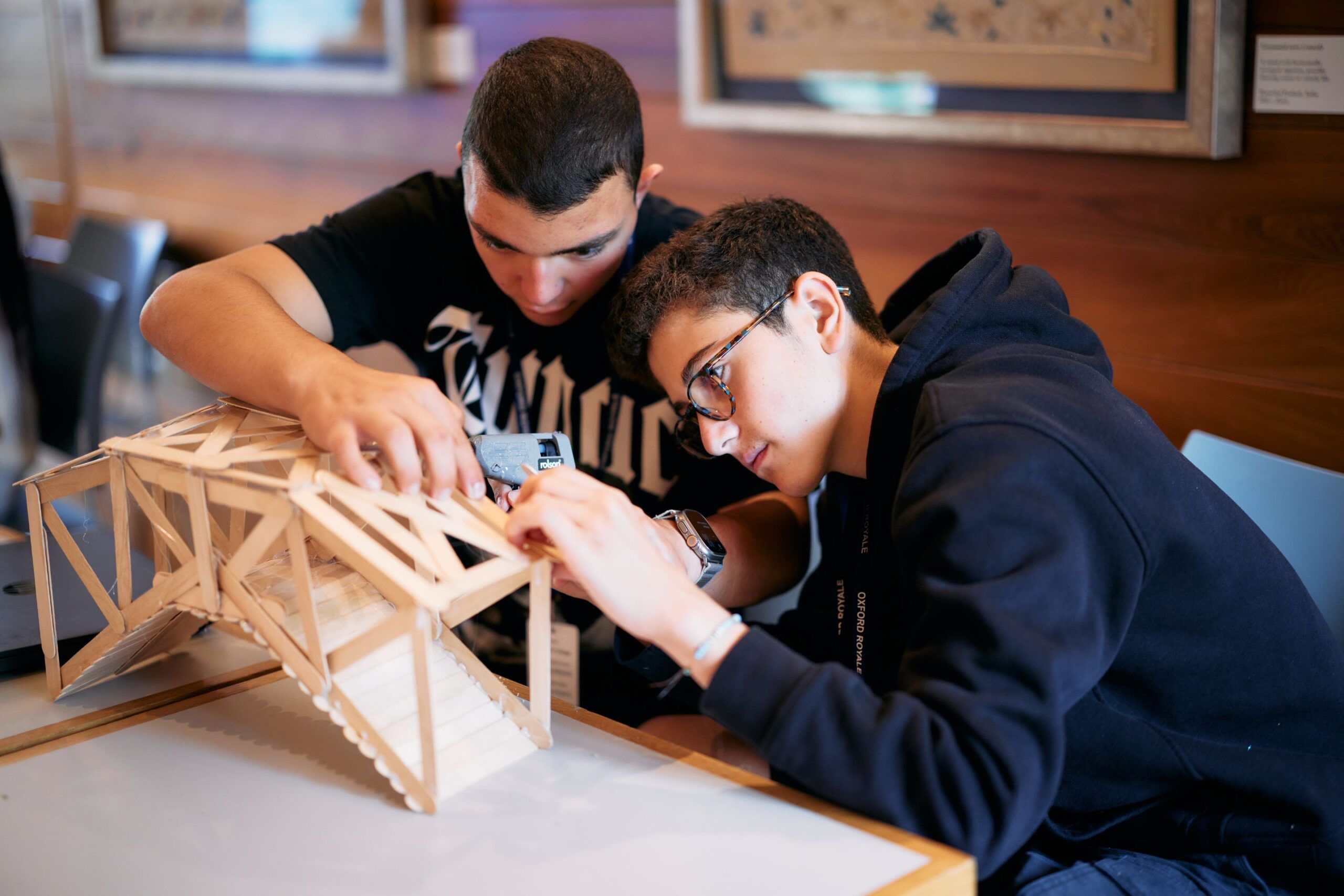 Two students building a model bridge