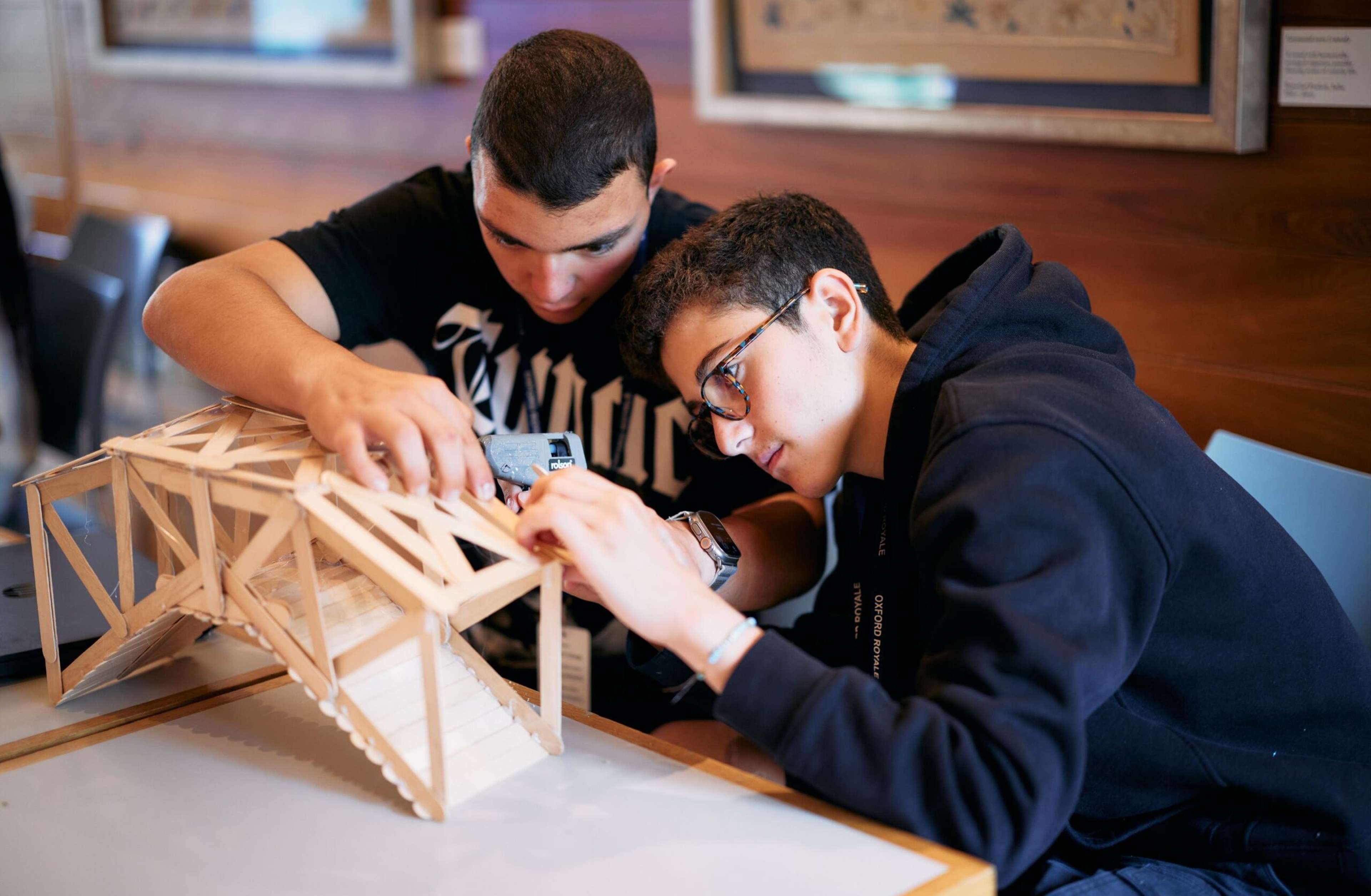 Two students building a model bridge