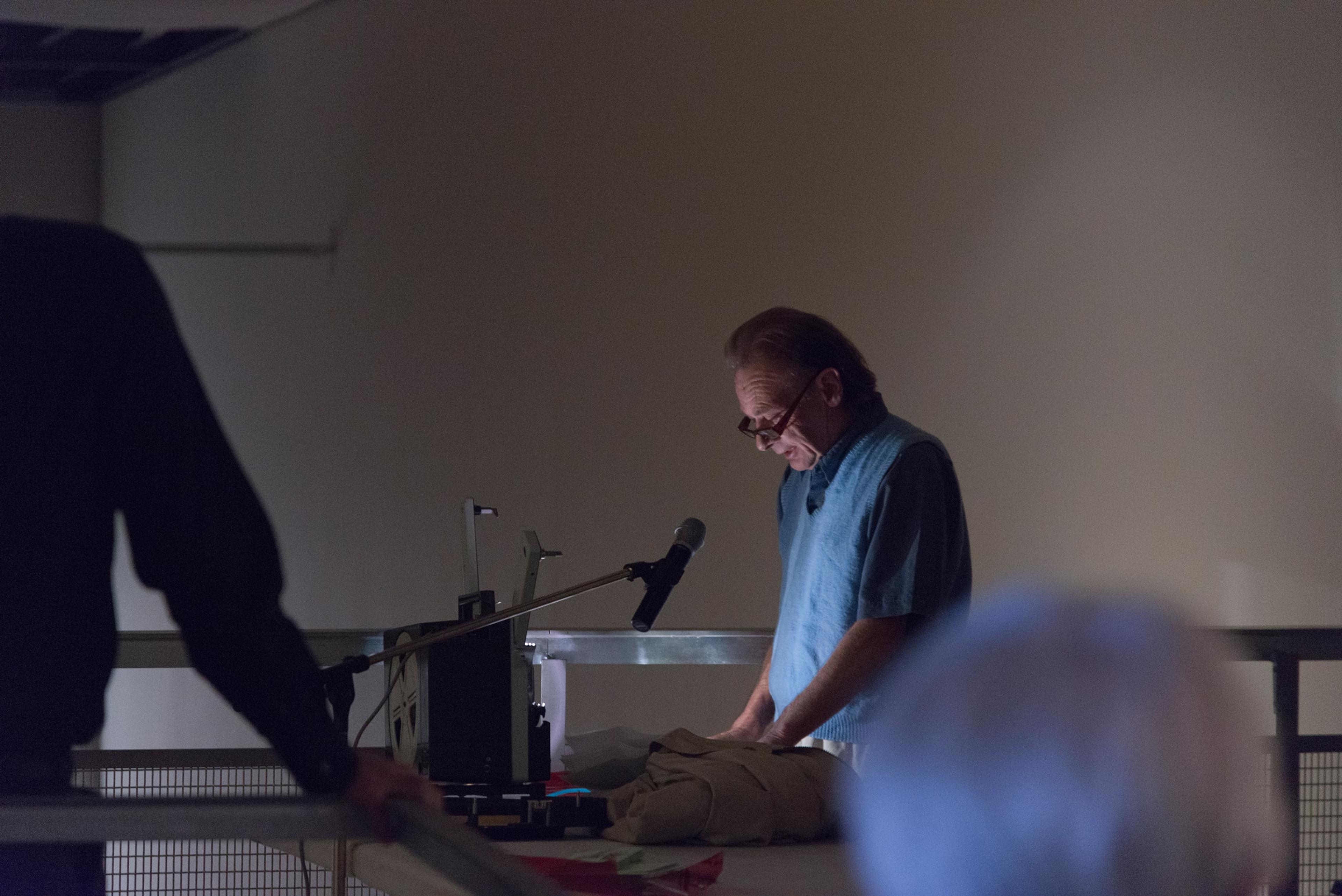 Hollis Frampton, A LECTURE, October 30, 1968, performed on February 11, 2014 by Martin Rumsby at the Adam Art Gallery. Script, 16mm projector, red filter, pipe cleaner. Courtesy of the Estate of Hollis Frampton. Photo: Shaun Waugh.