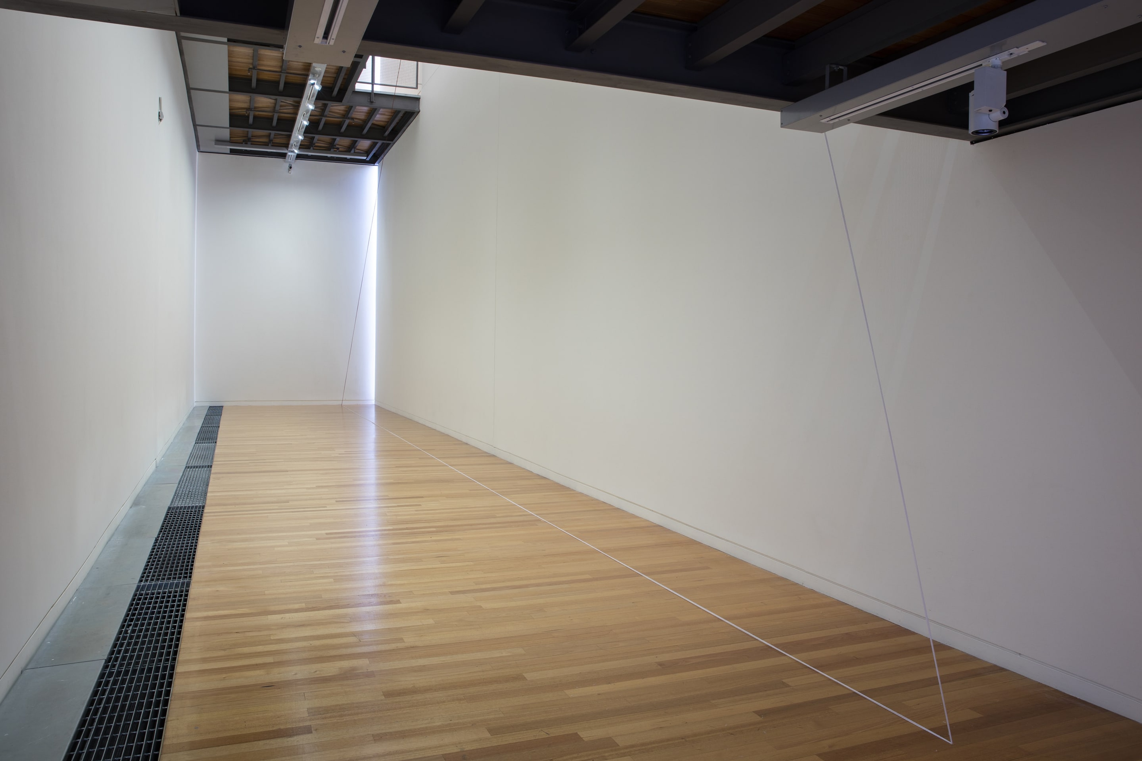 Detail view of Fred Sandback, Untitled (Triangle with Broken Leg) 1988, acrylic yarn. Courtesy of the Fred Sandback Estate, Jensen Gallery, Sydney and Fox/Jensen, Auckland. In the exhibition Inhabiting Space at the Adam Art Gallery Te Pātaka Toi, Victoria University of Wellington (photo: Shaun Waugh)