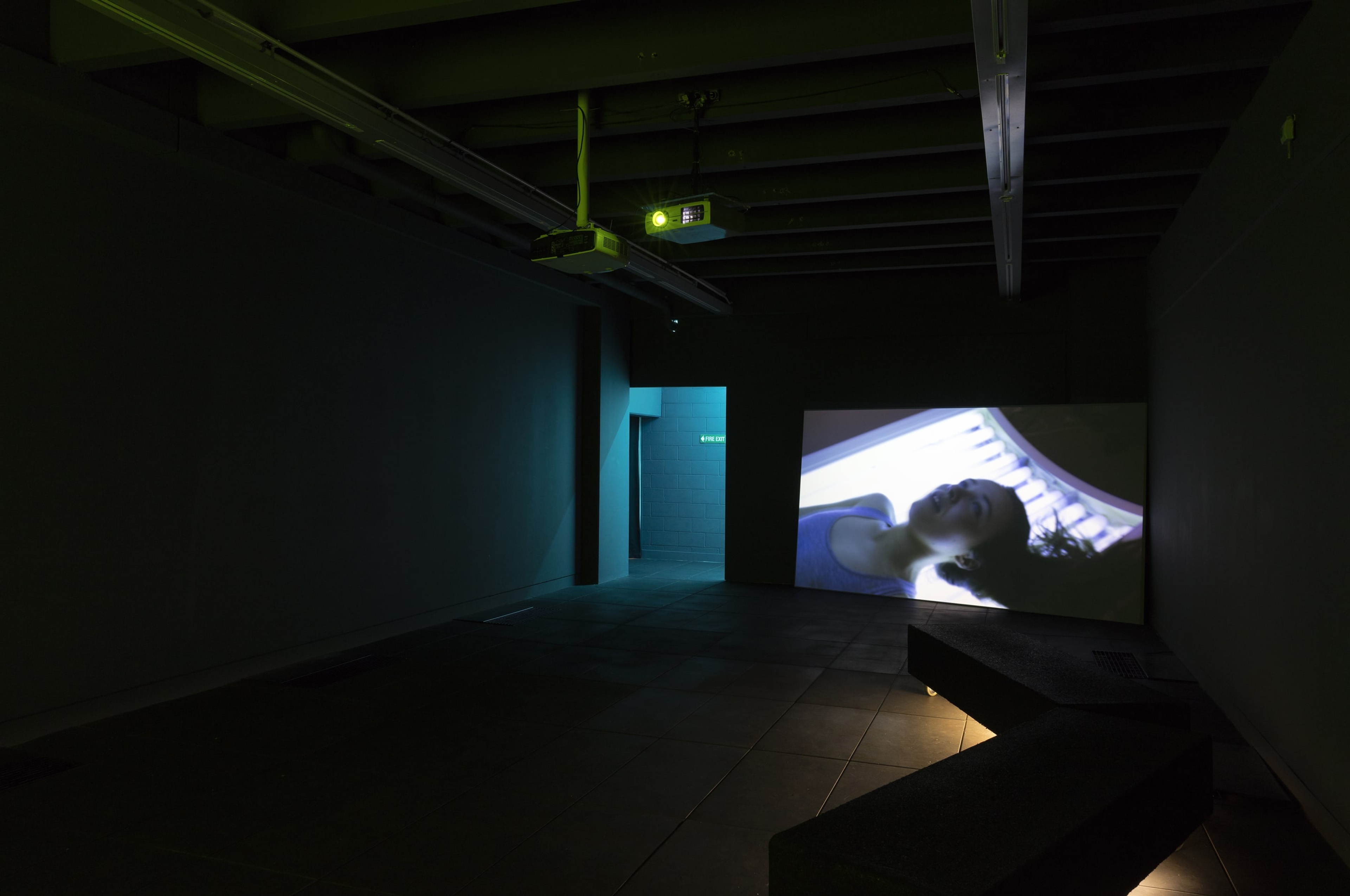 Installation view, Juliet Carpenter, Summer of Supine, 2015, single channel video projection, coloured lighting, courtesy of the artist. In the exhibition Inhabiting Space at the Adam Art Gallery Te Pātaka Toi, Victoria University of Wellington (photo: Shaun Waugh)