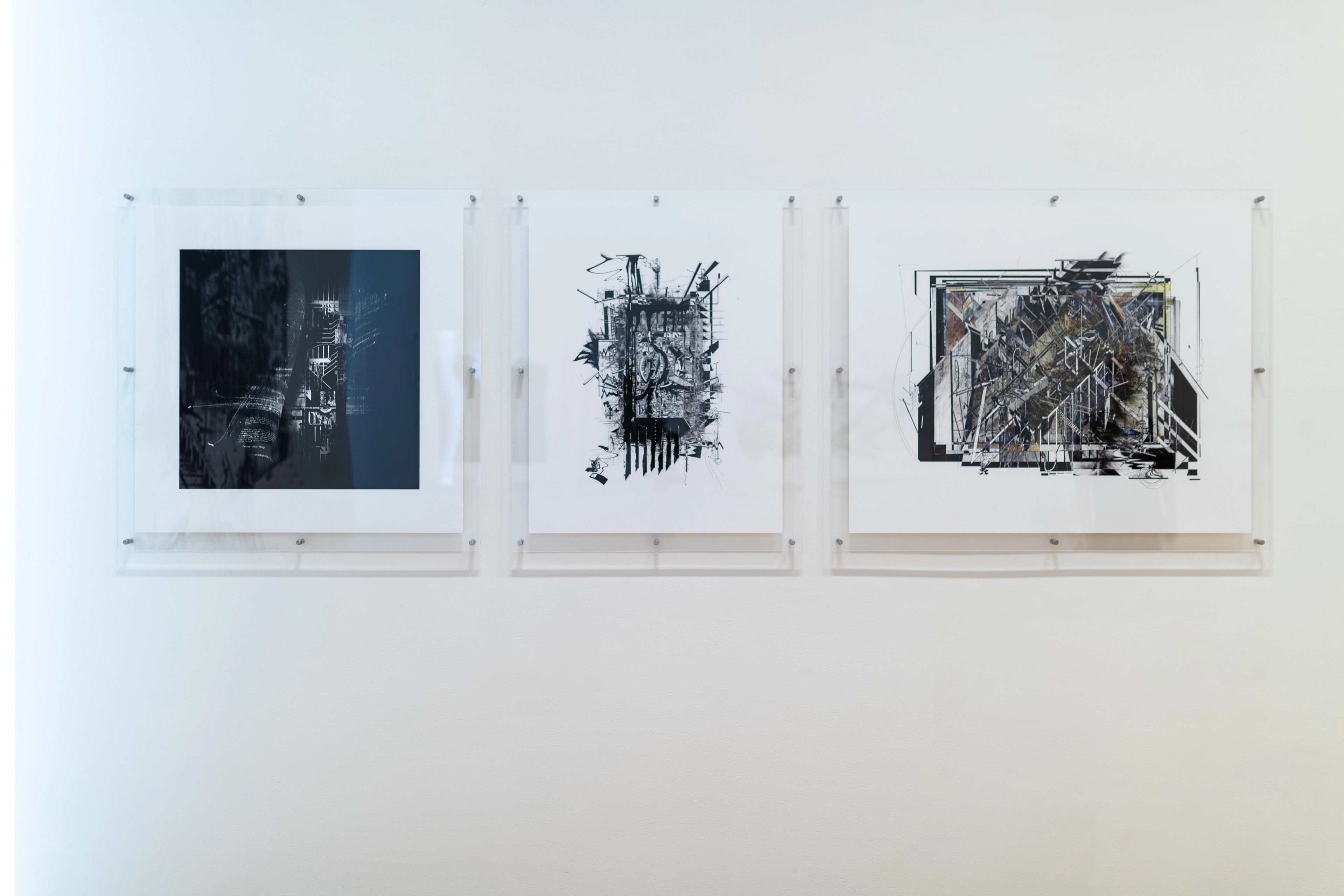 Straight on view of a gallery wall with text and square architectural images in perspex mounts. Daniel K. Brown 