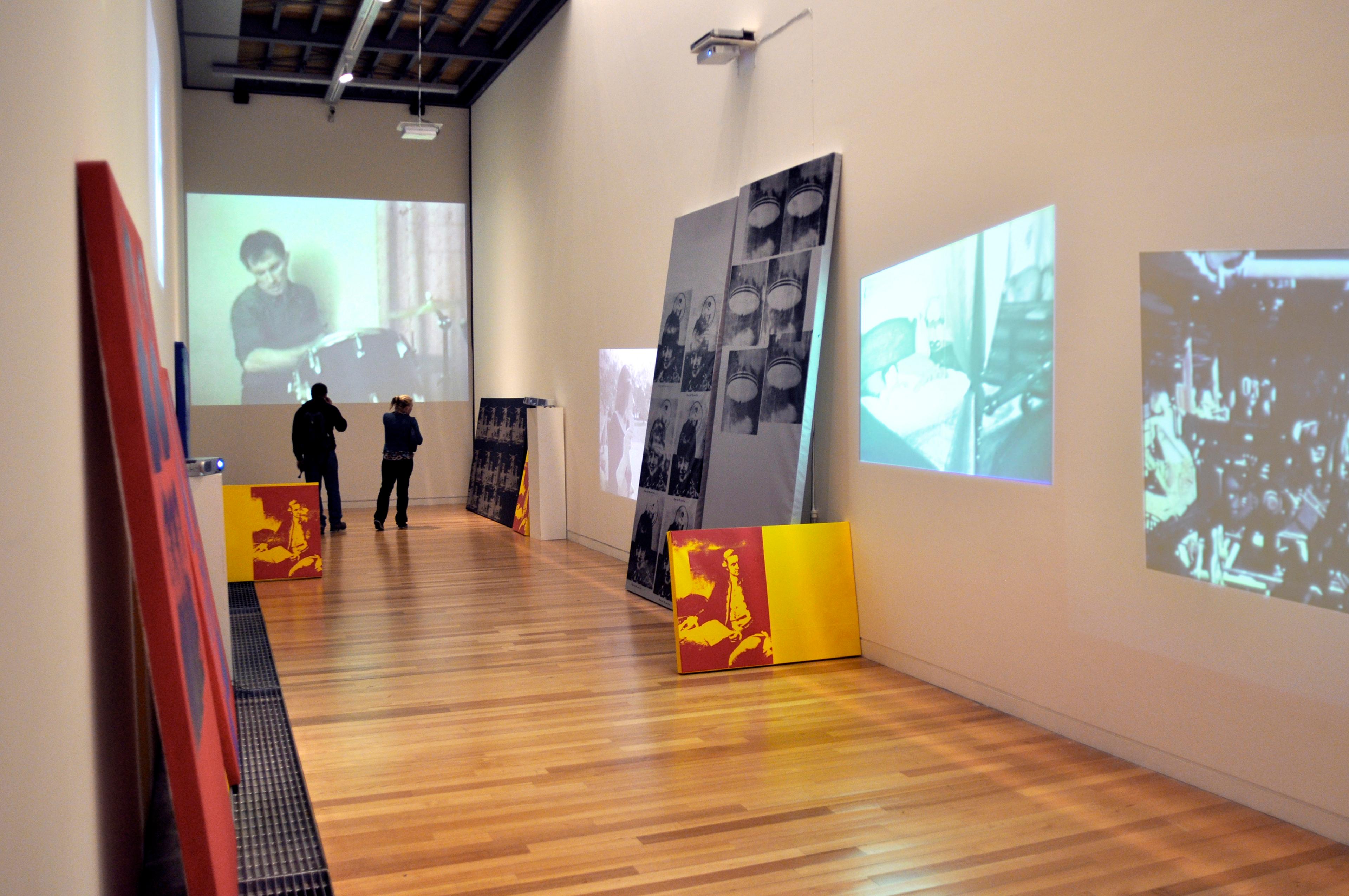 Ronnie van Hout, 1981- 1982, 2010. projected SD DVDs, silk screen inks on primed and painted stretched canvas. Installation view, Object Lessons: A Musical Fiction, Adam Art Gallery Te Pātaka Toi, Victoria University of Wellington. Photo: Michael Salmon