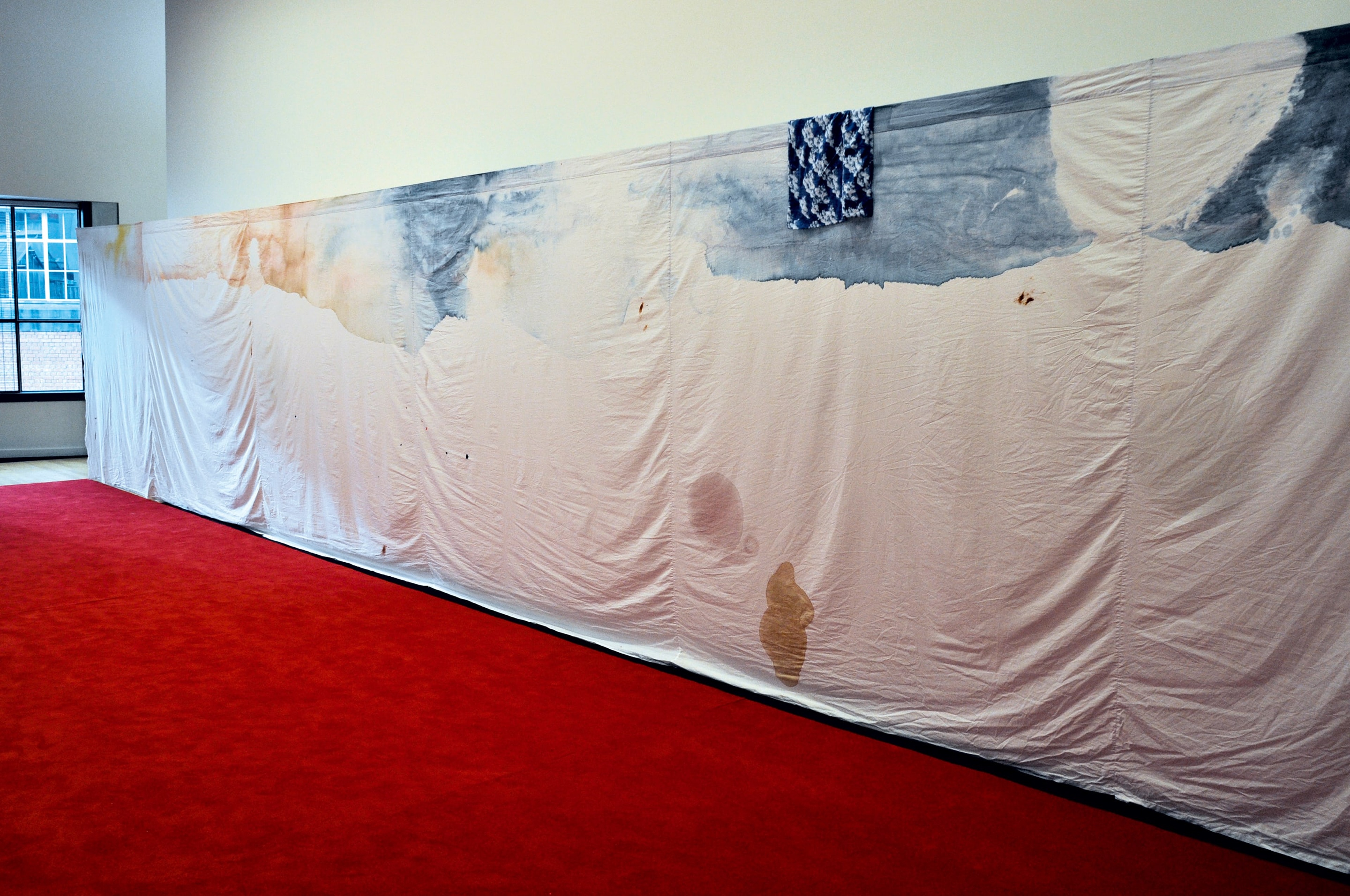 Kate Newby, Falling over with surprise, 2009, carpet, sheets, oil, coffee stains, red wine, lip balm, wood, scaffolding, paint, ceramics. Installation view, The Future is Unwritten, Adam Art Gallery Te Pātaka Toi, Victoria University of Wellington, 2009 