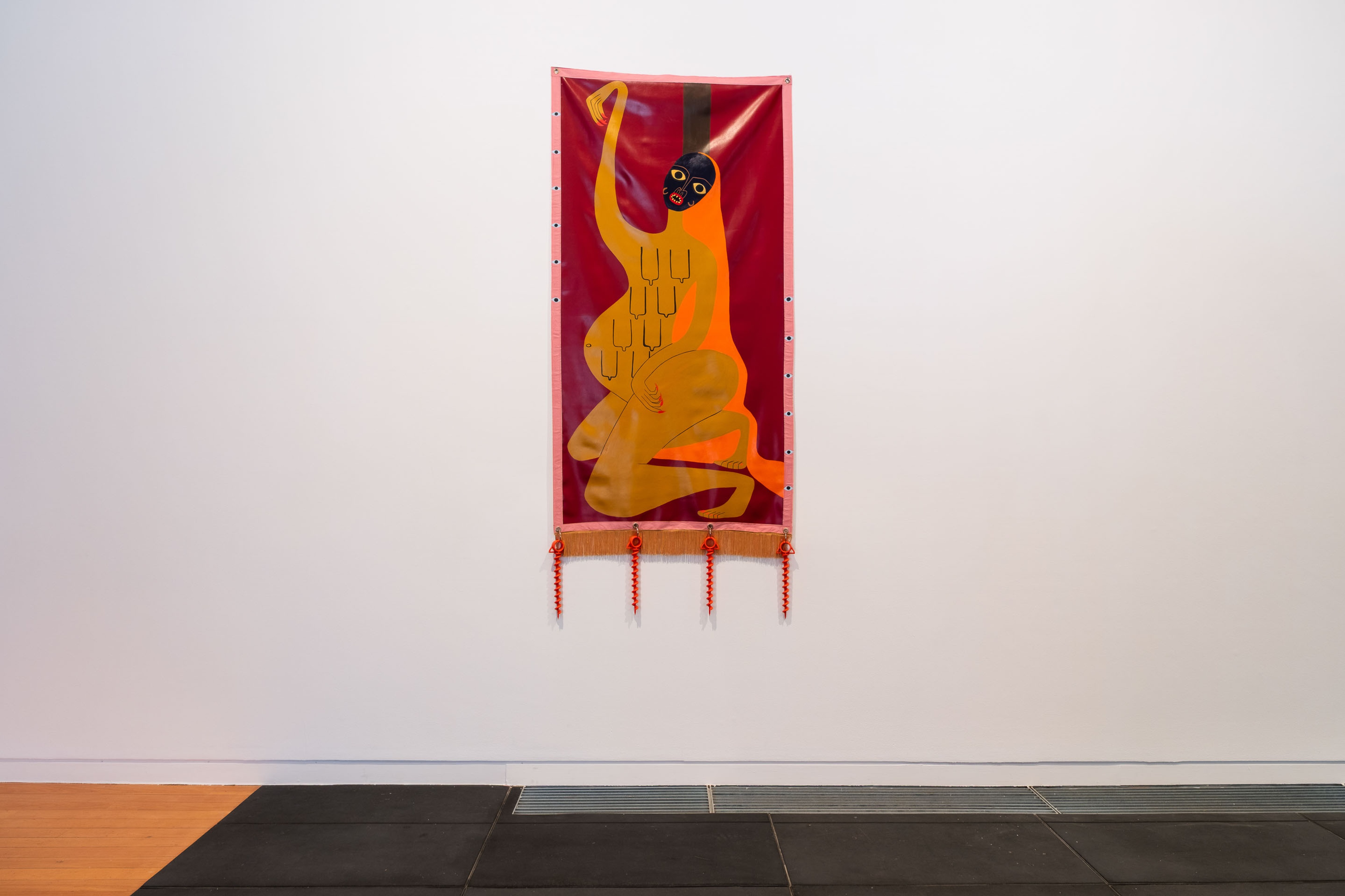 Melanie Tangaere Baldwin, Pou Karanga, 2023, acrylic on vinyl with found ribbon edging, vintage fringe, ground anchors, 2600 x 960 mm. Installation view Whai Wāhi, Te Pātaka Toi Adam Art Gallery, 2025. Photo: Ted Whitaker.