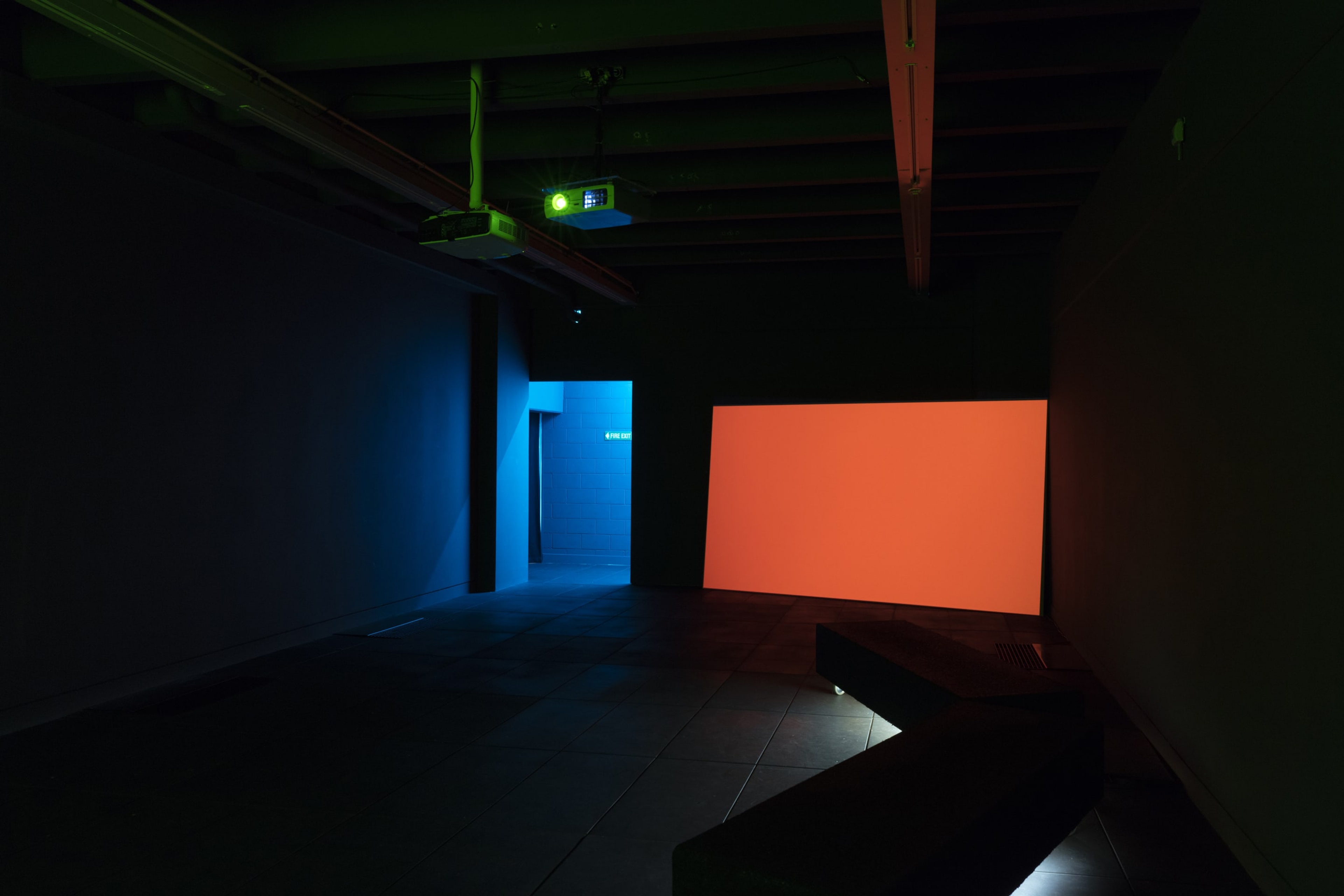 Installation view, Juliet Carpenter, Summer of Supine, 2015, single channel video projection, coloured lighting, courtesy of the artist. In the exhibition Inhabiting Space at the Adam Art Gallery Te Pātaka Toi, Victoria University of Wellington (photo: Shaun Waugh)