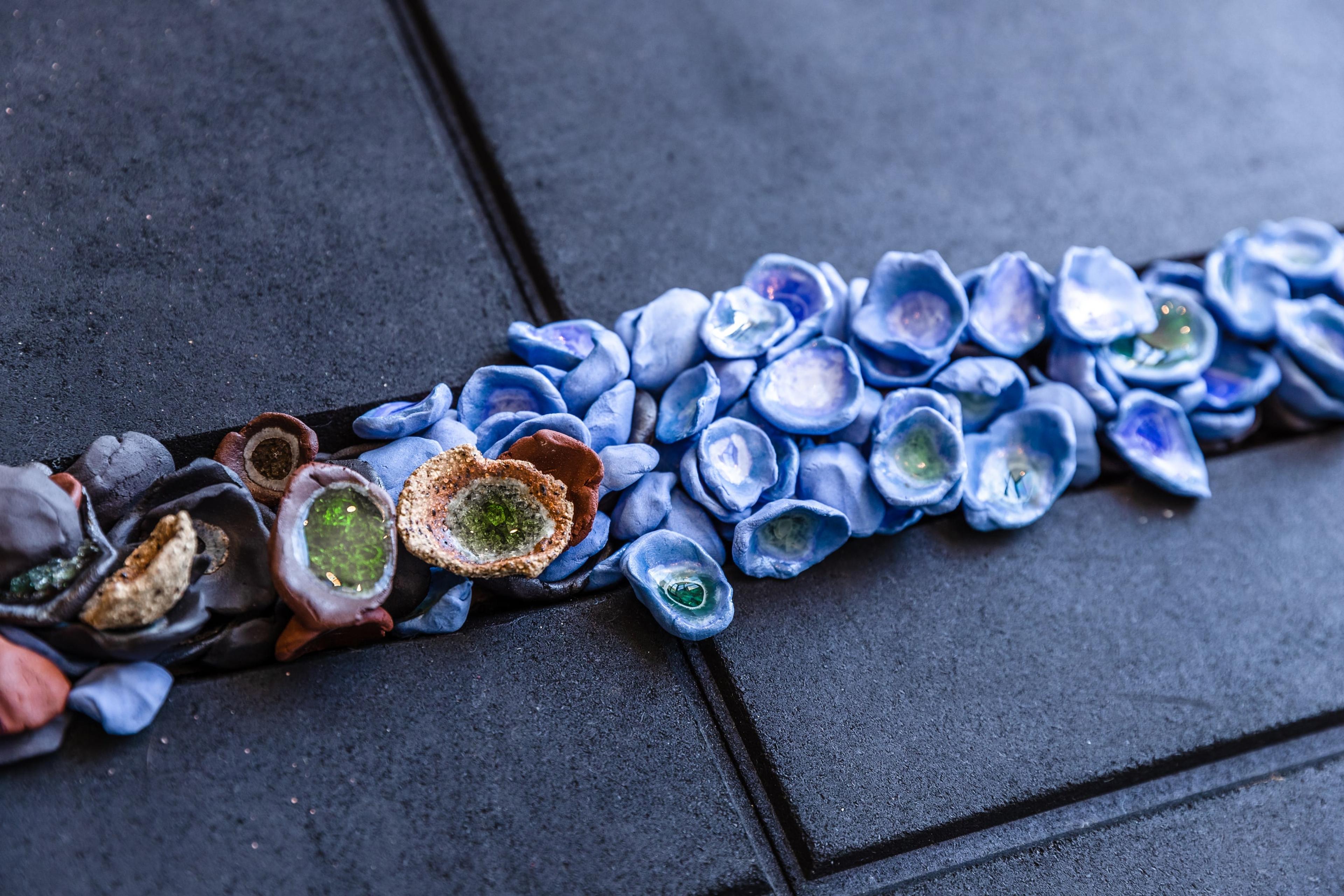 a groove in rubber flooring tiles filled with small ceramic objects