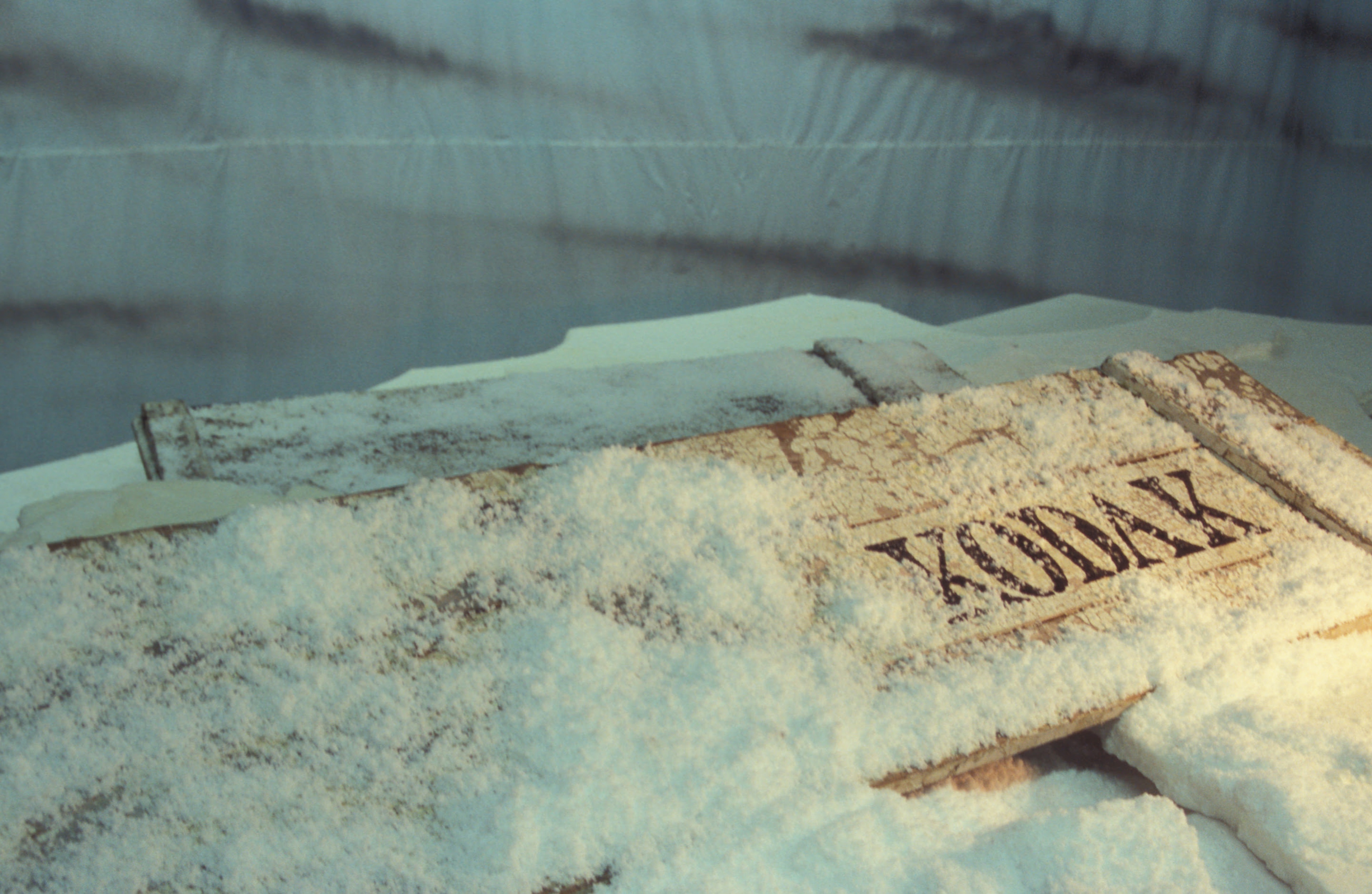 Stuart Shepherd, Discover this, 2005, fake snow, styrofoam, aged wood, acrylic paint, cameras, digital printer, penguin suit, hoodies and mittens. Installation view, Breaking Ice: Re-Visioning Antarctica, Adam Art Gallery Te Pātaka Toi, Victoria University of Wellington, 2005