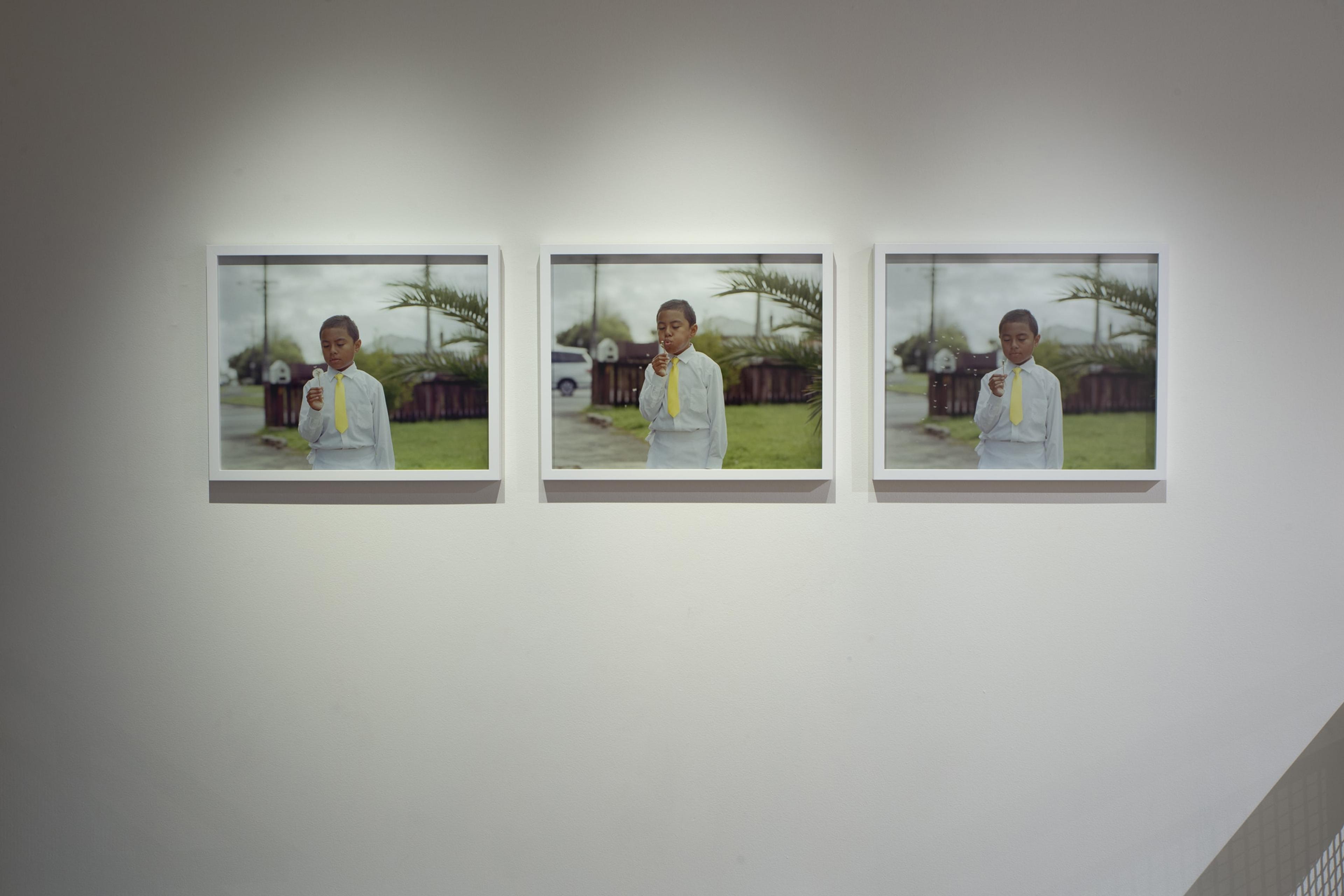 Edith Amituanai, Isaac with Dandelion on White Sunday, 2012, three pigment inkjet prints