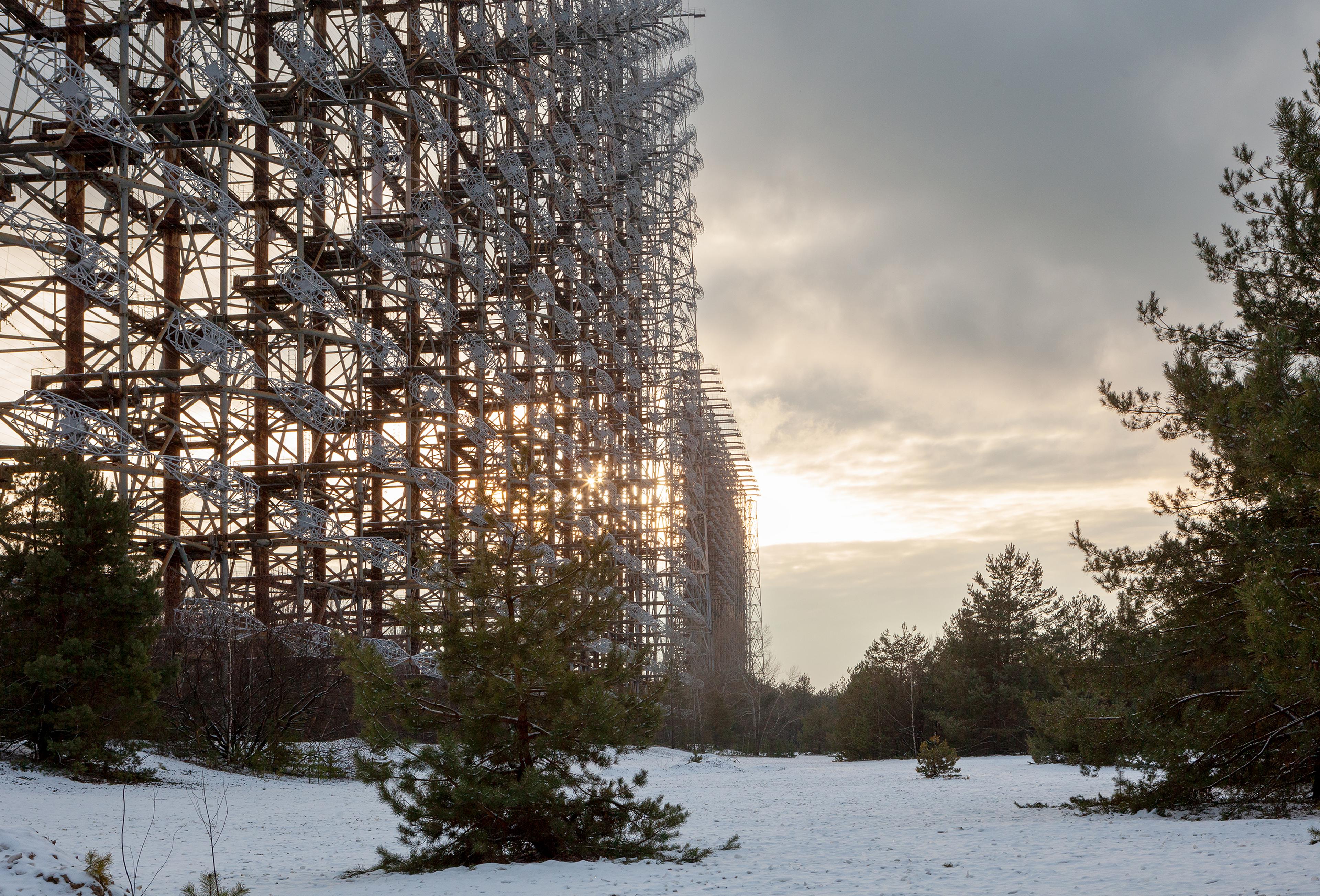 Colour photograph of large metal framework structure in a snowy landscape