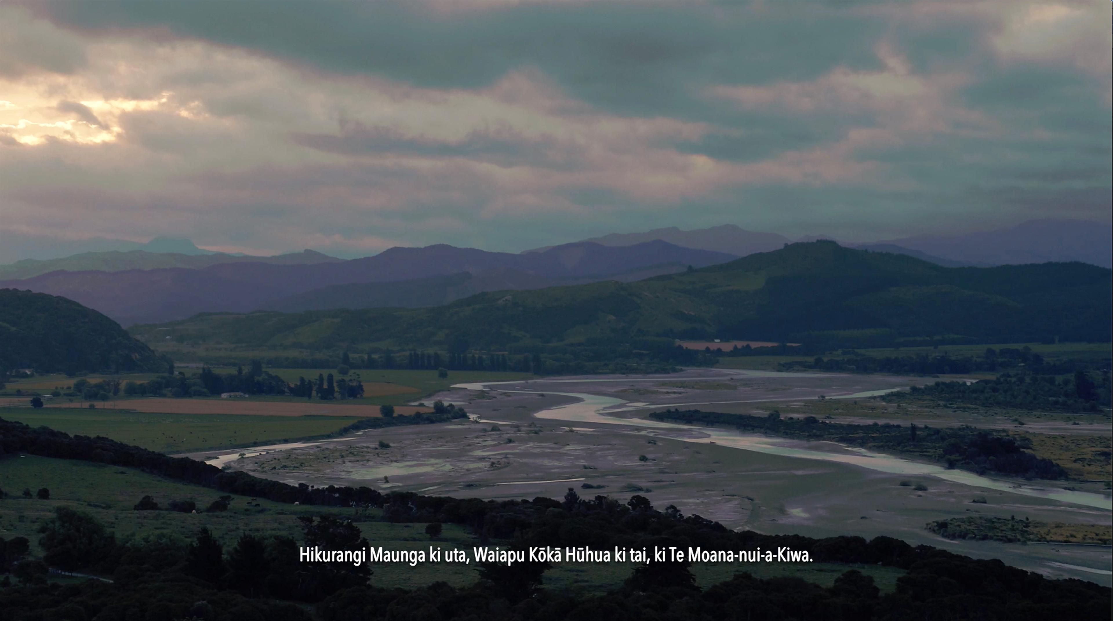 Production still image showing drone footage of a river valley
