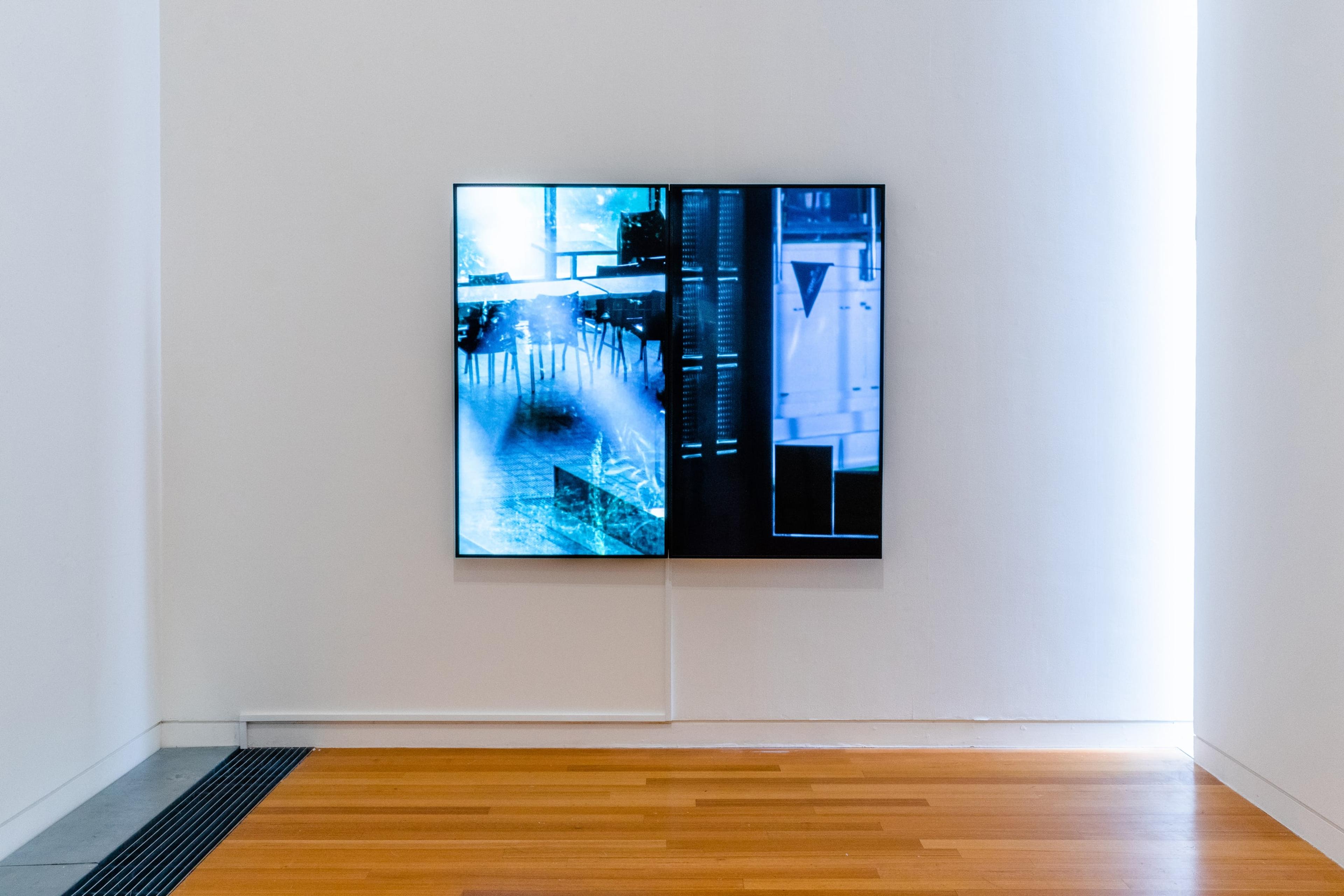 a large square TV screen on a white wall, with black and blue geometric patterns on them.