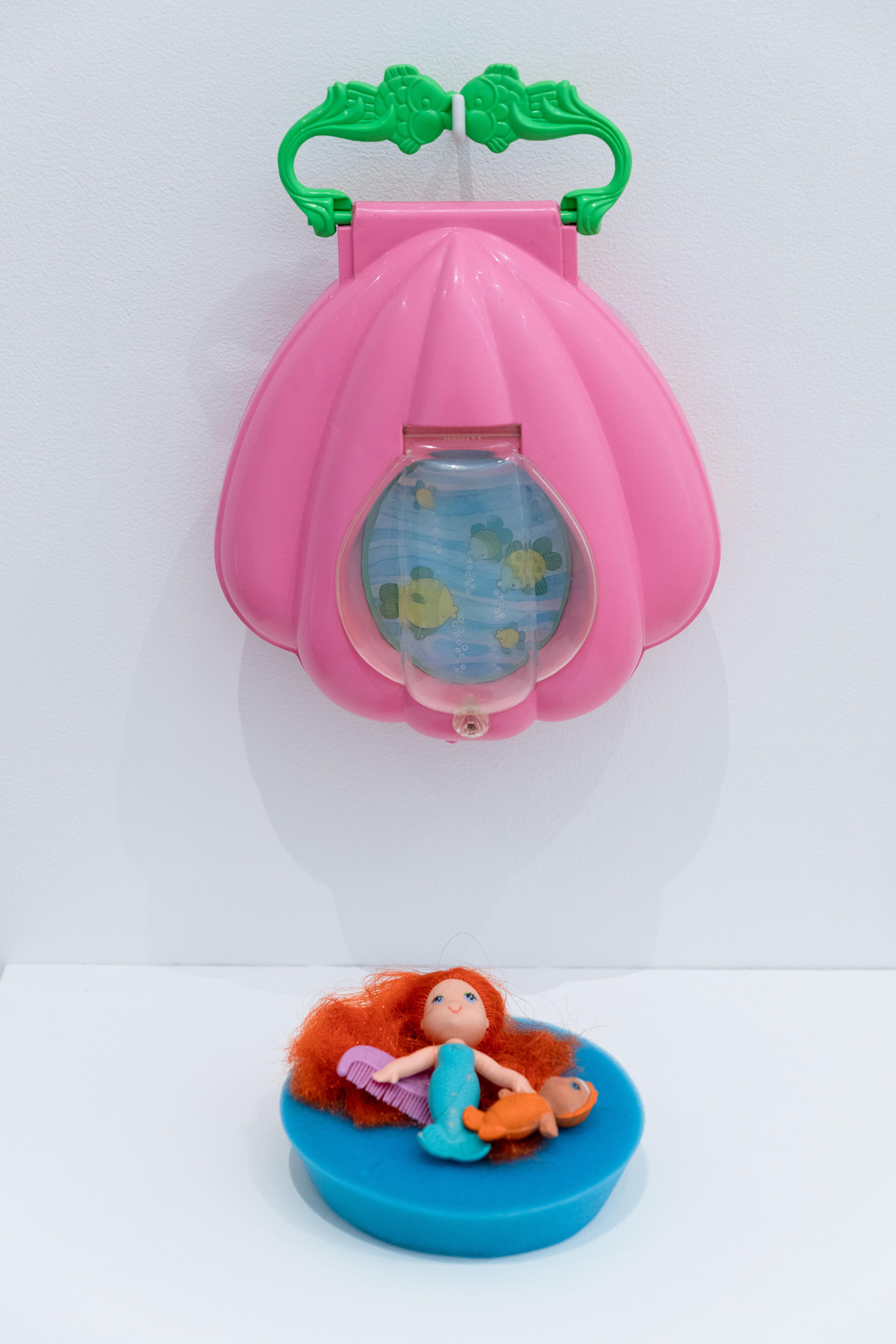 Coral, See Wees doll, 1979; Finella, See Wees baby doll, 1981; and See Wees carrying case with kissing fishes handle, 1980, both collection Megan Dunn and Fearne Crane. Installation view, Megan Dunn: The Mermaid Chronicles, Te Pātaka Toi Adam Art Gallery, Te Herenga Waka Victoria University of Wellington, 2022. Photo: Ted Whitaker