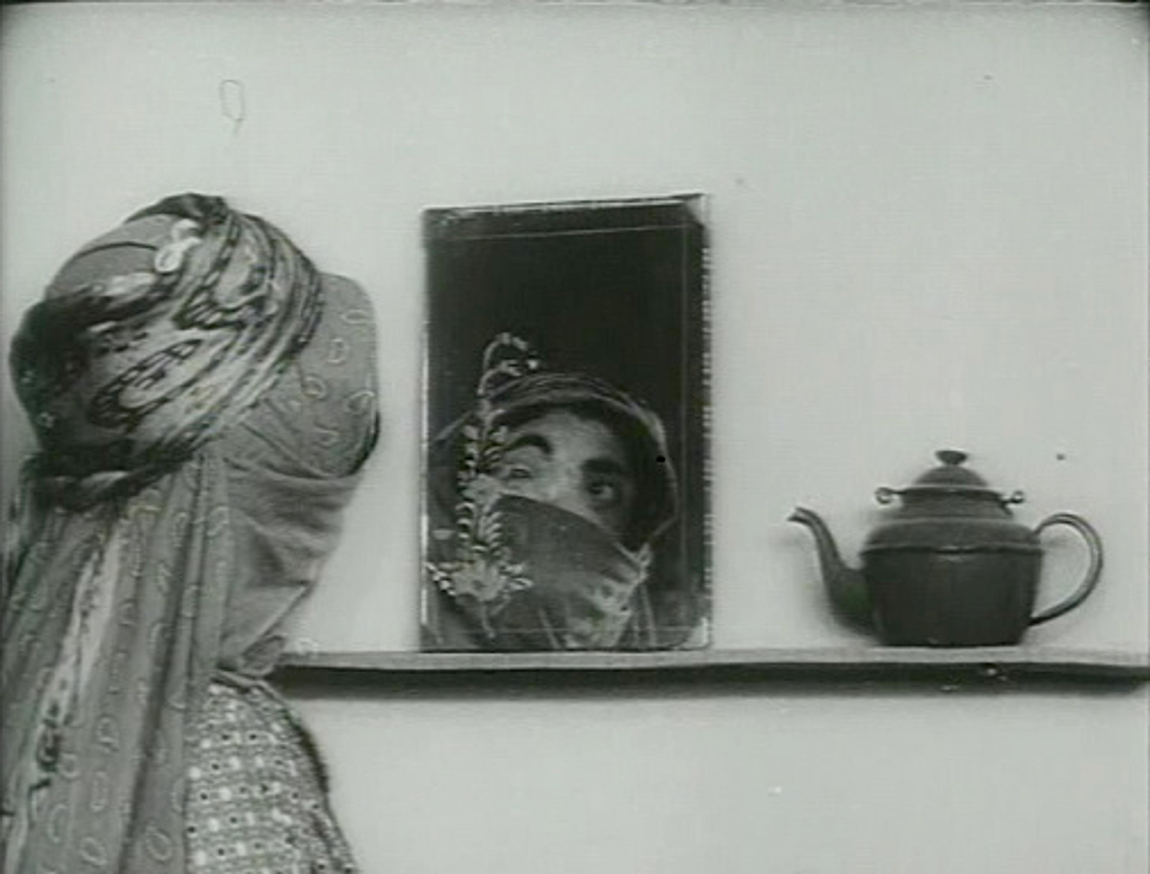 Women wearing head covering, looking into a mirror.