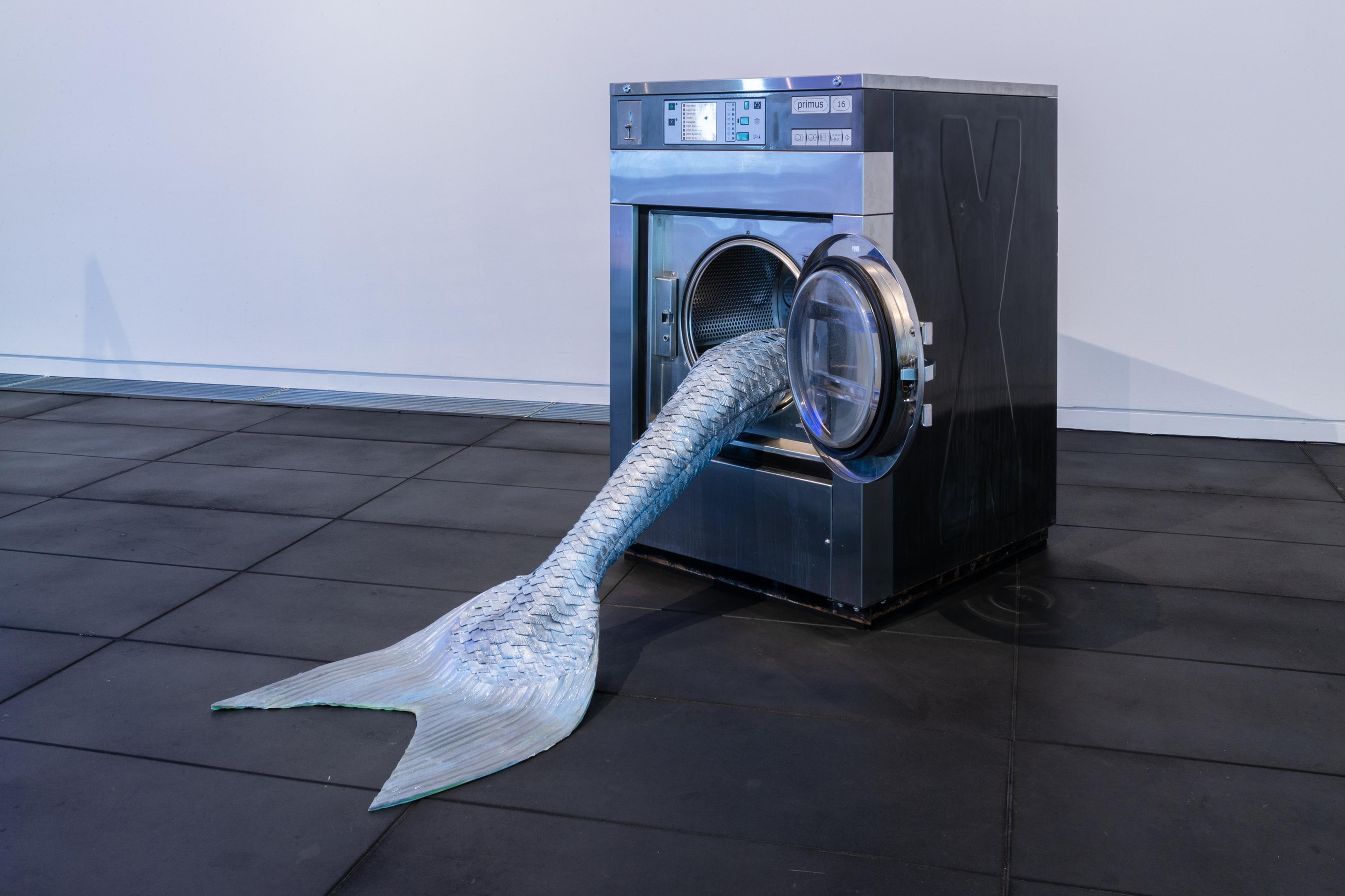 Olivia Erlanger, Pergusa (Gris), 2022, silicone and paint, commercial washing machine, courtesy of the artist and DM Office, New York. Installation view, Megan Dunn: The Mermaid Chronicles, Te Pātaka Toi Adam Art Gallery, Te Herenga Waka Victoria University of Wellington, 2022. Photo: Ted Whitaker