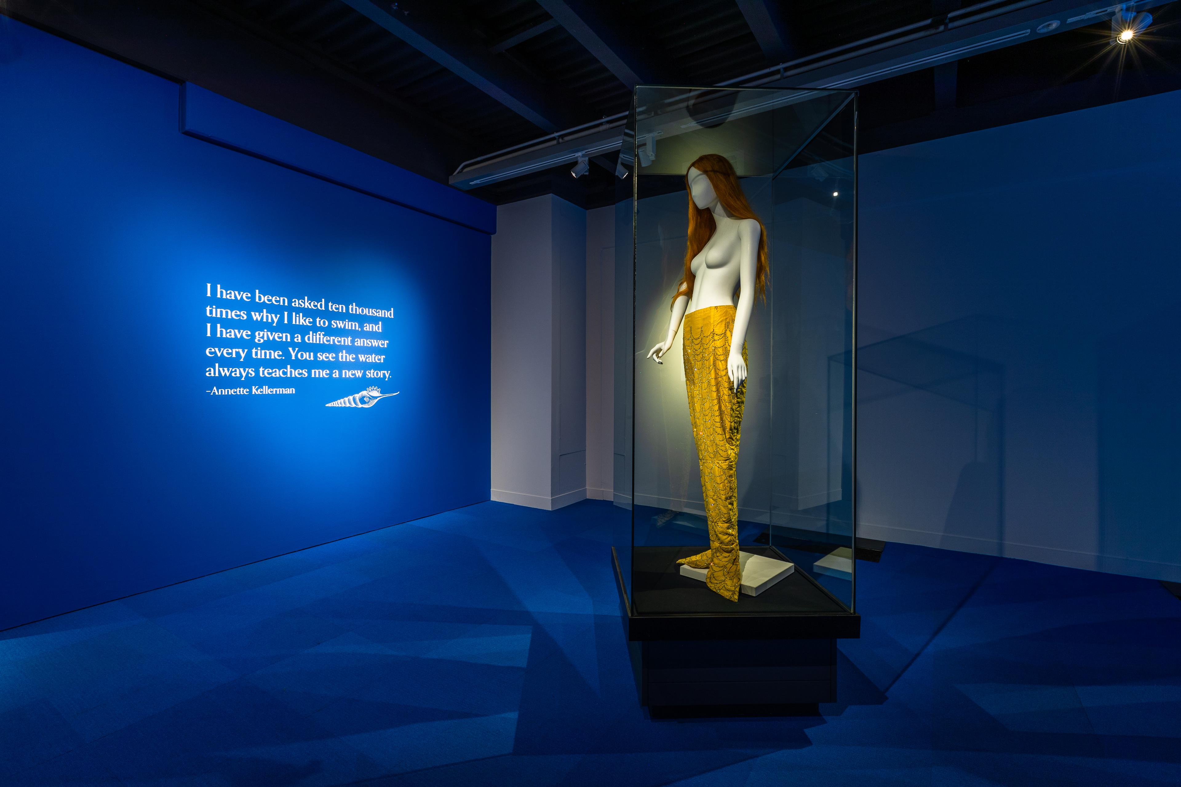 Annette Kellerman tail in vitrine with quote on wall behind