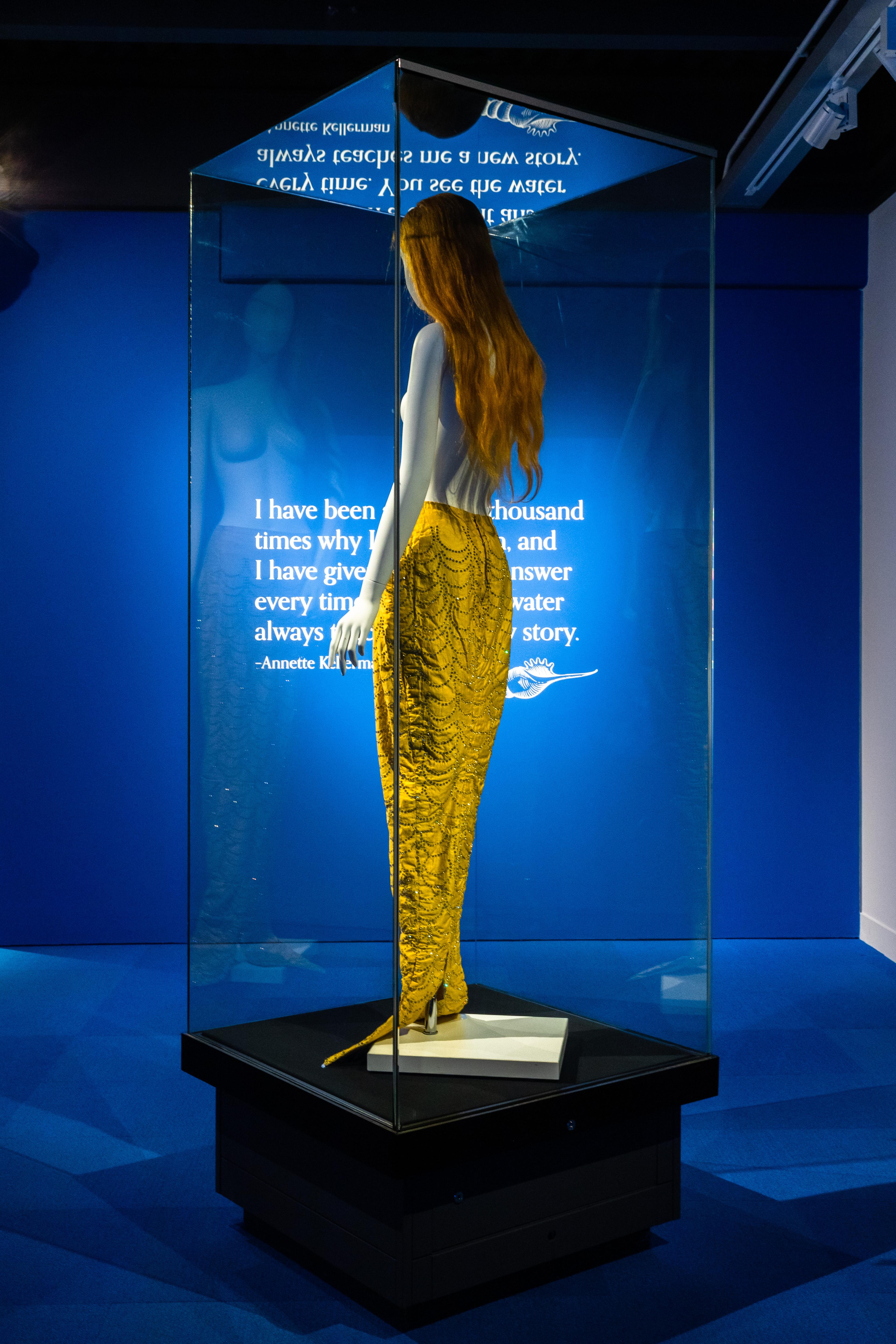 Annette Kellerman mermaid tail in vitrine with quote on wall behind