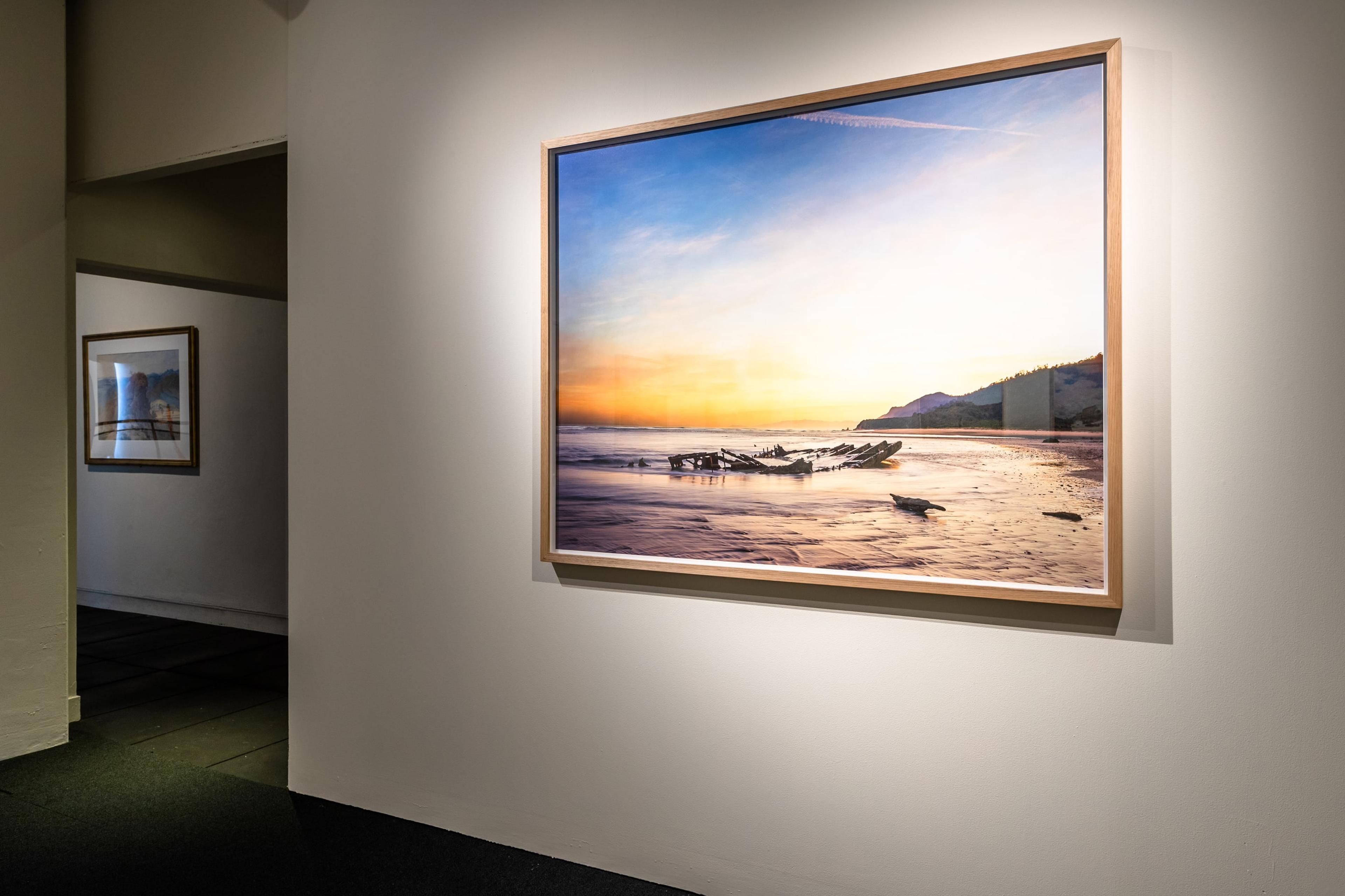 Chris Corson Scott, Winter Morning, Remains of the Coal Barge SS Lawrence, Mokihinui, 2016, archival pigment print. Courtesy of the artist and Trish Clark Gallery, Auckland. Installation view, Tēnei Ao Tūroa – This Enduring World, Te Pātaka Toi Adam Art Gallery, Victoria University Wellington. Photo: Ted Whitaker