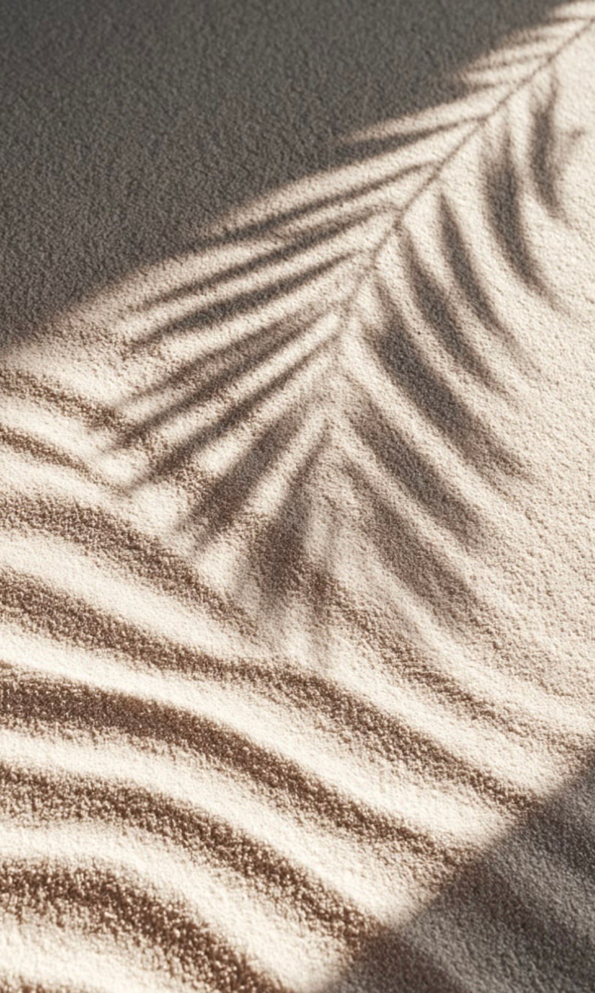 Warmer NÉA Hair-Spa-Bereich mit Sand und Palmwedel-Schatten.