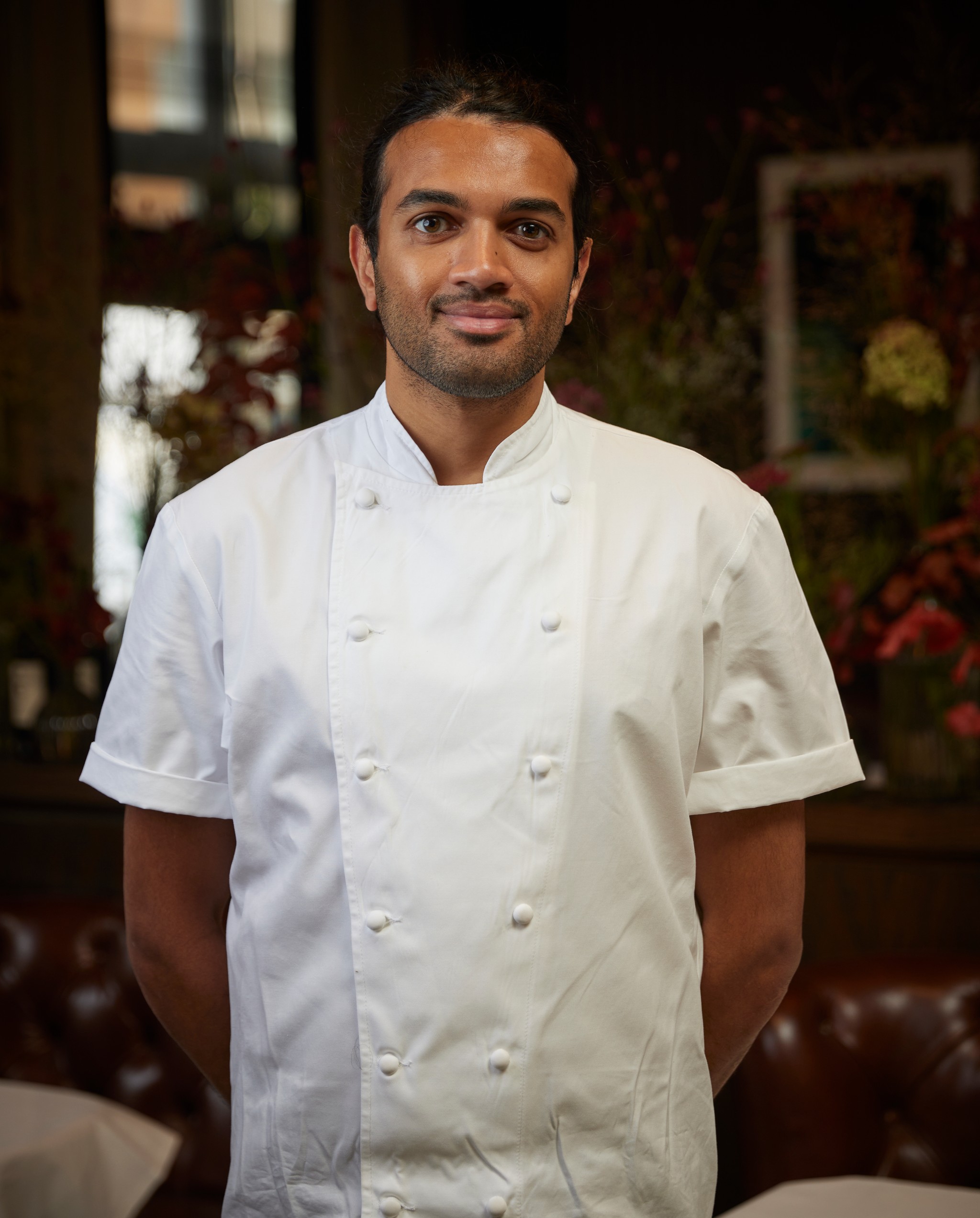 Sous Chef Rishi Patel standing in Marcus Belgravia dining room with his hands behind his back