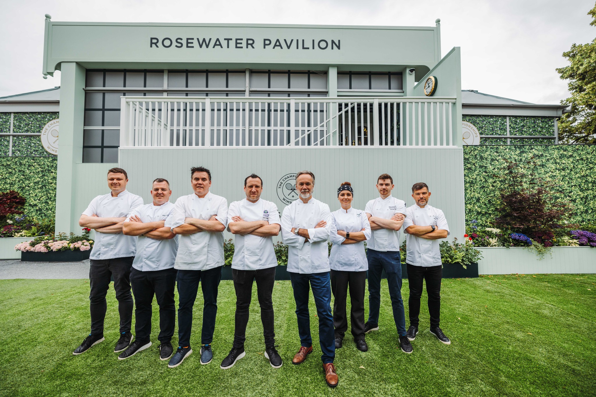 Eight chefs standing in front of the Rosewater Pavilion at 2023 Wimbledon Championships
