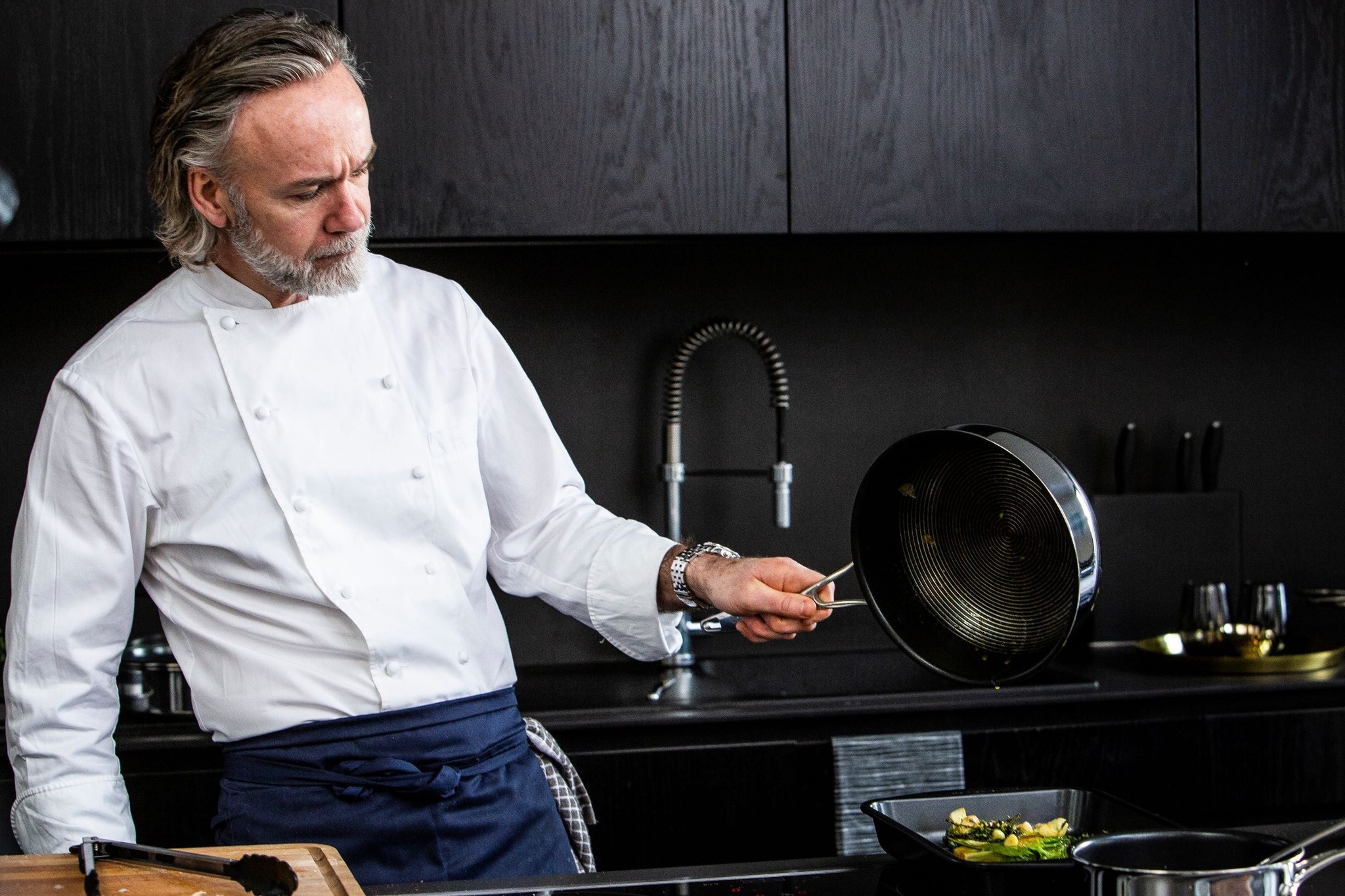 Marcus Wareing pouring oil onto a plate from a Circulon pan