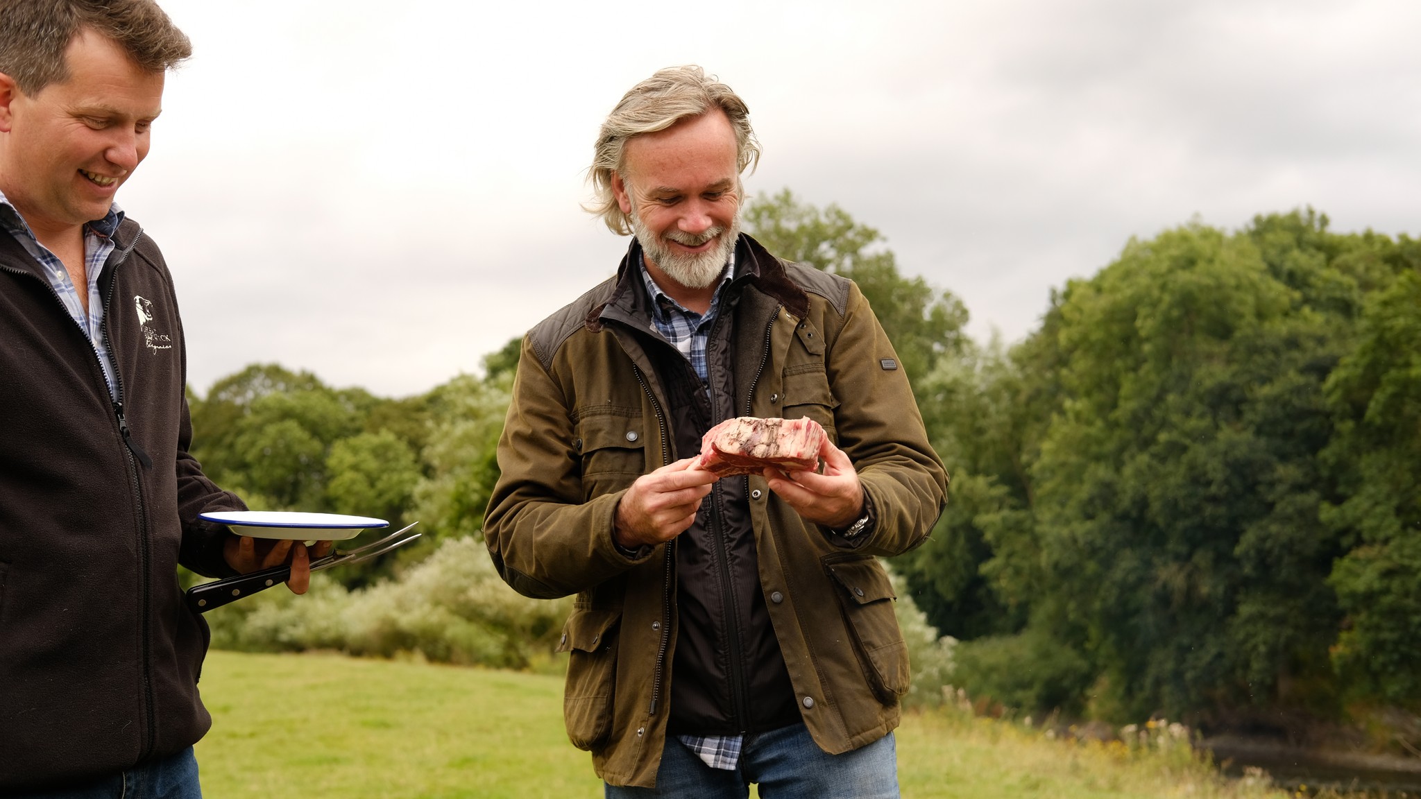 Marcus Wareing holding a piece of steak in a field from Tales from a Kitchen Garden