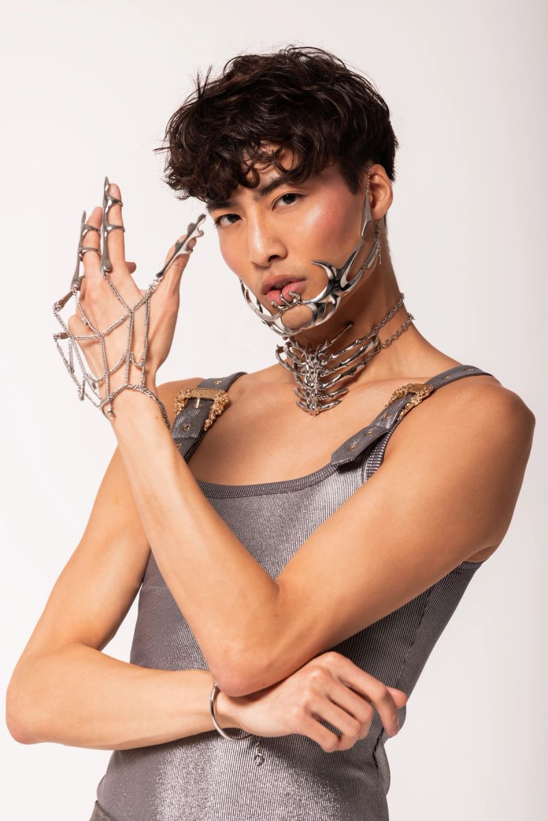 A portrait of Jason Kwan in a silver vest and silver accessories
