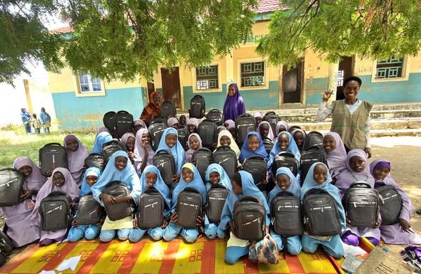 Schoolgirls hold backpacks during a HALI-supported education activity.
