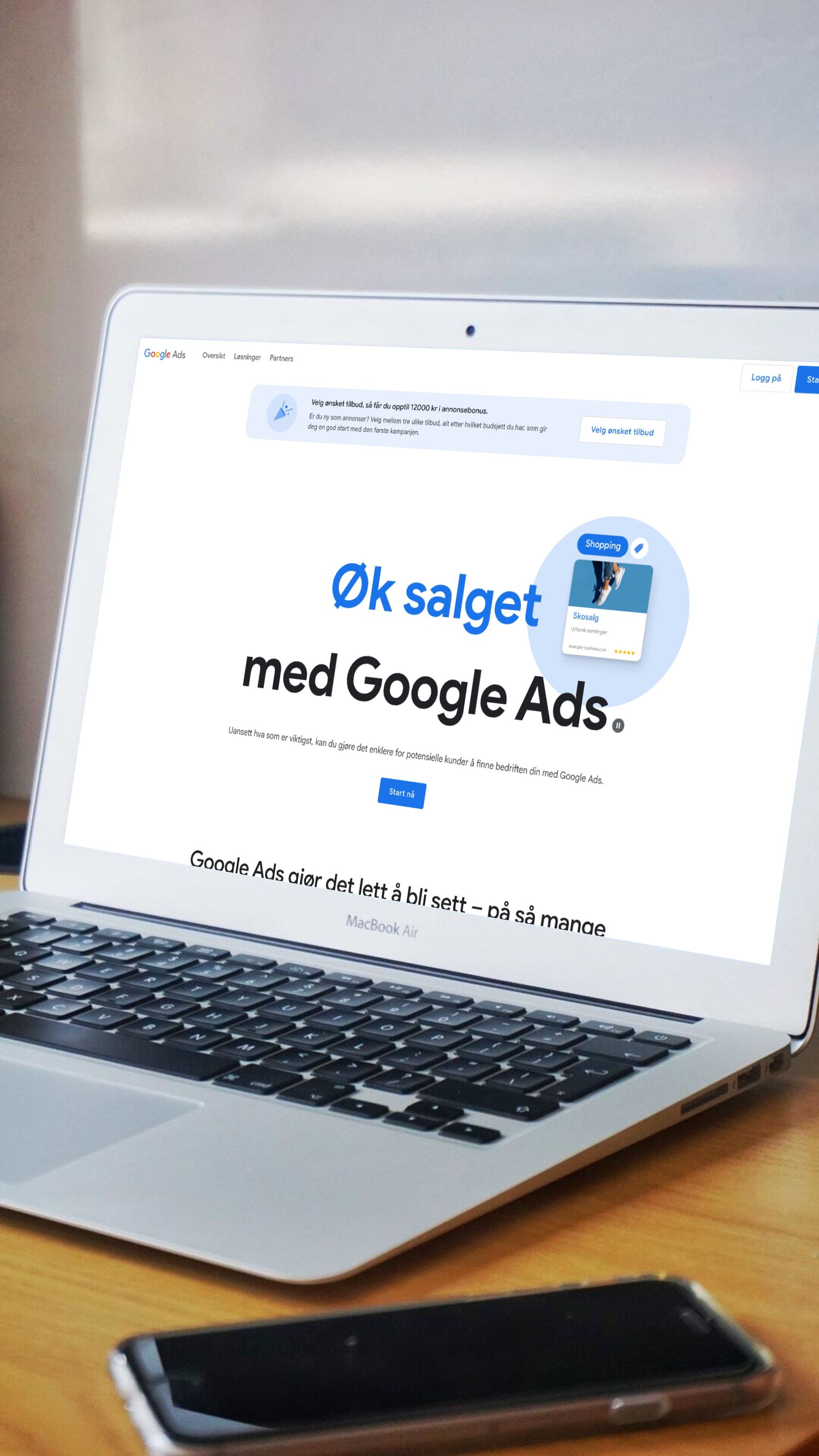 MacBook Air viser Google Ads-kampanje med teksten "Øk salget med Google Ads" og eksempel på shopping-annonse, illustrerer digital markedsføring