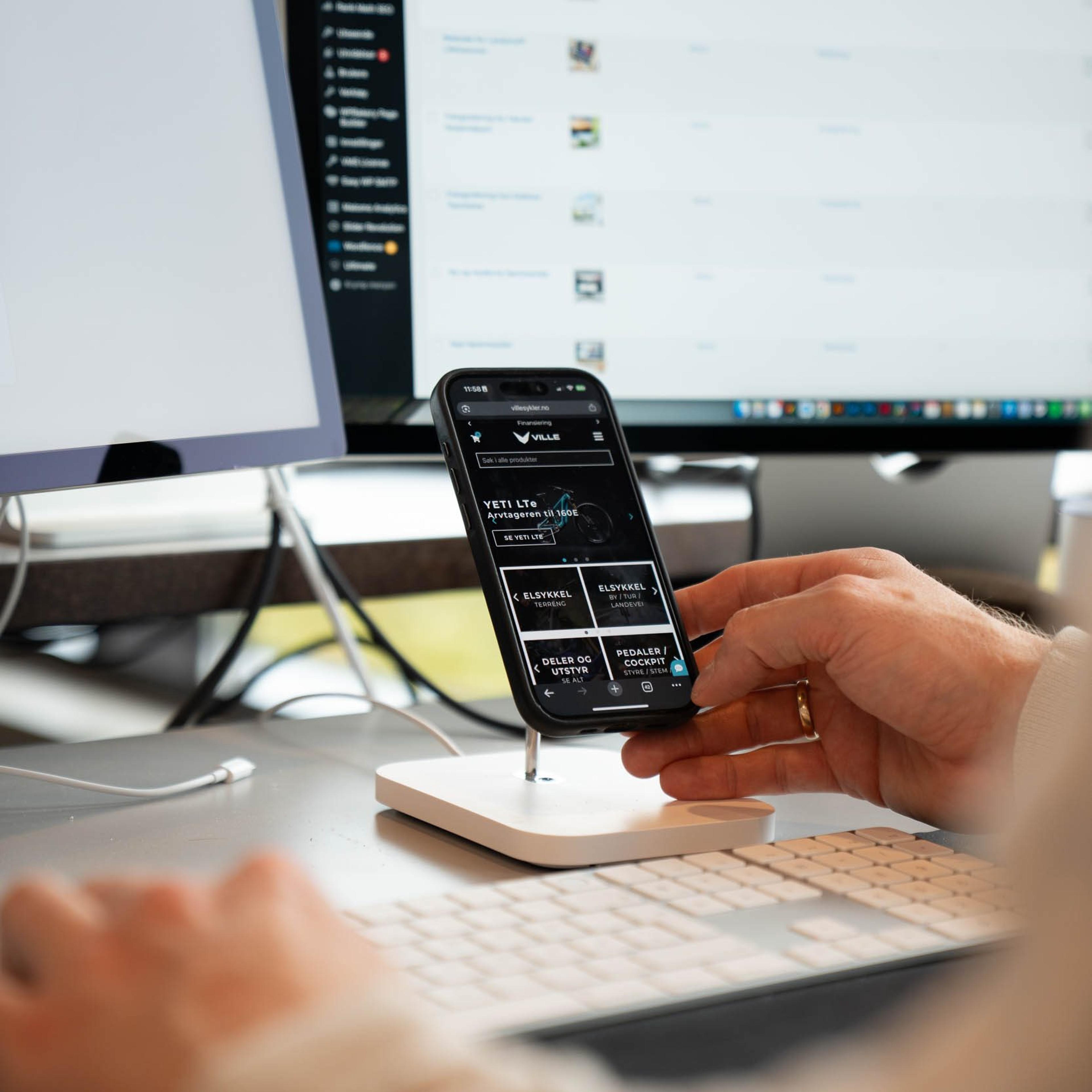 Bilde av en person som står og trykker på en iPhone
