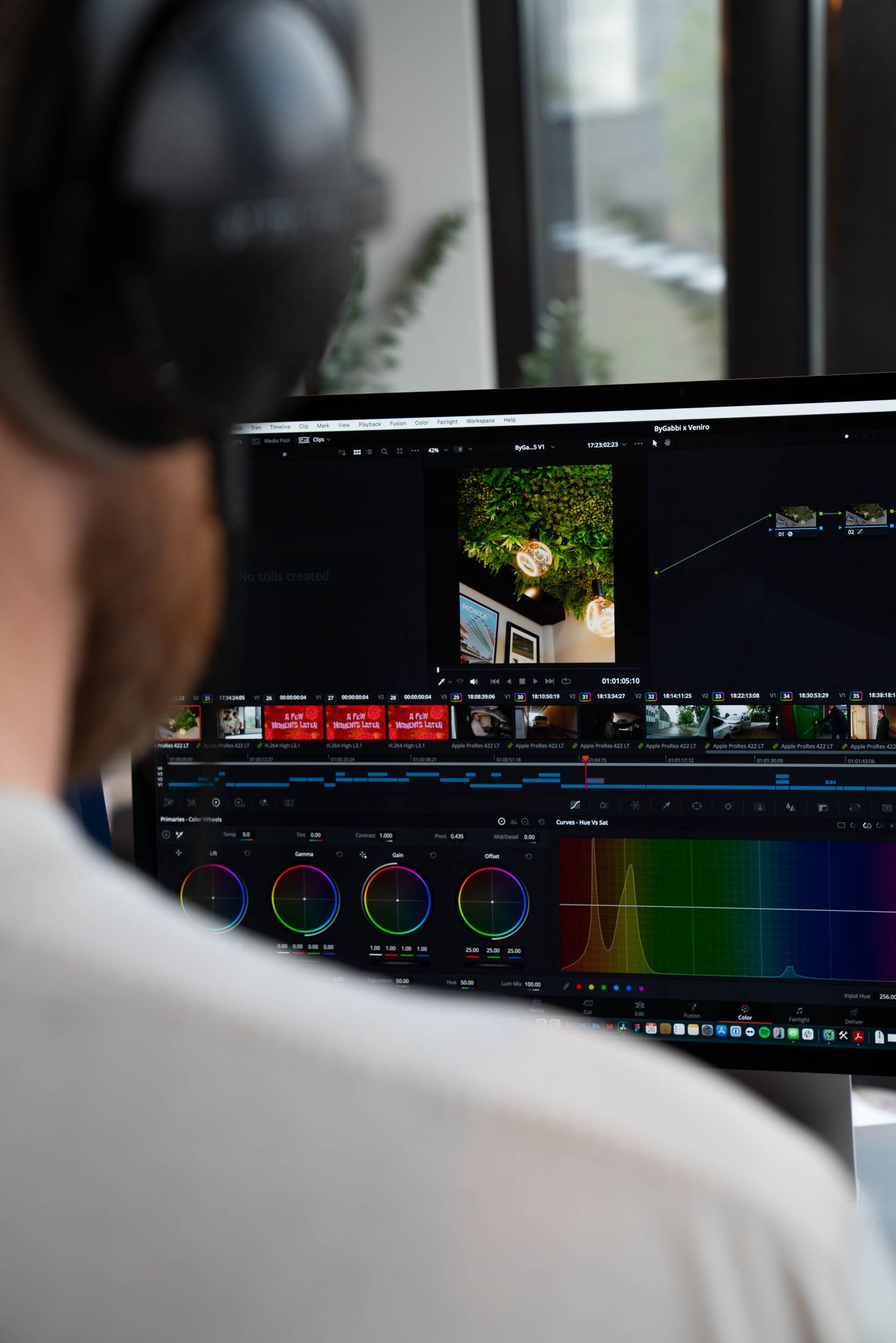 Videograf arbeider ved datamaskinen med fargegradering og redigering av videoinnhold i profesjonell redigeringsprogramvare.