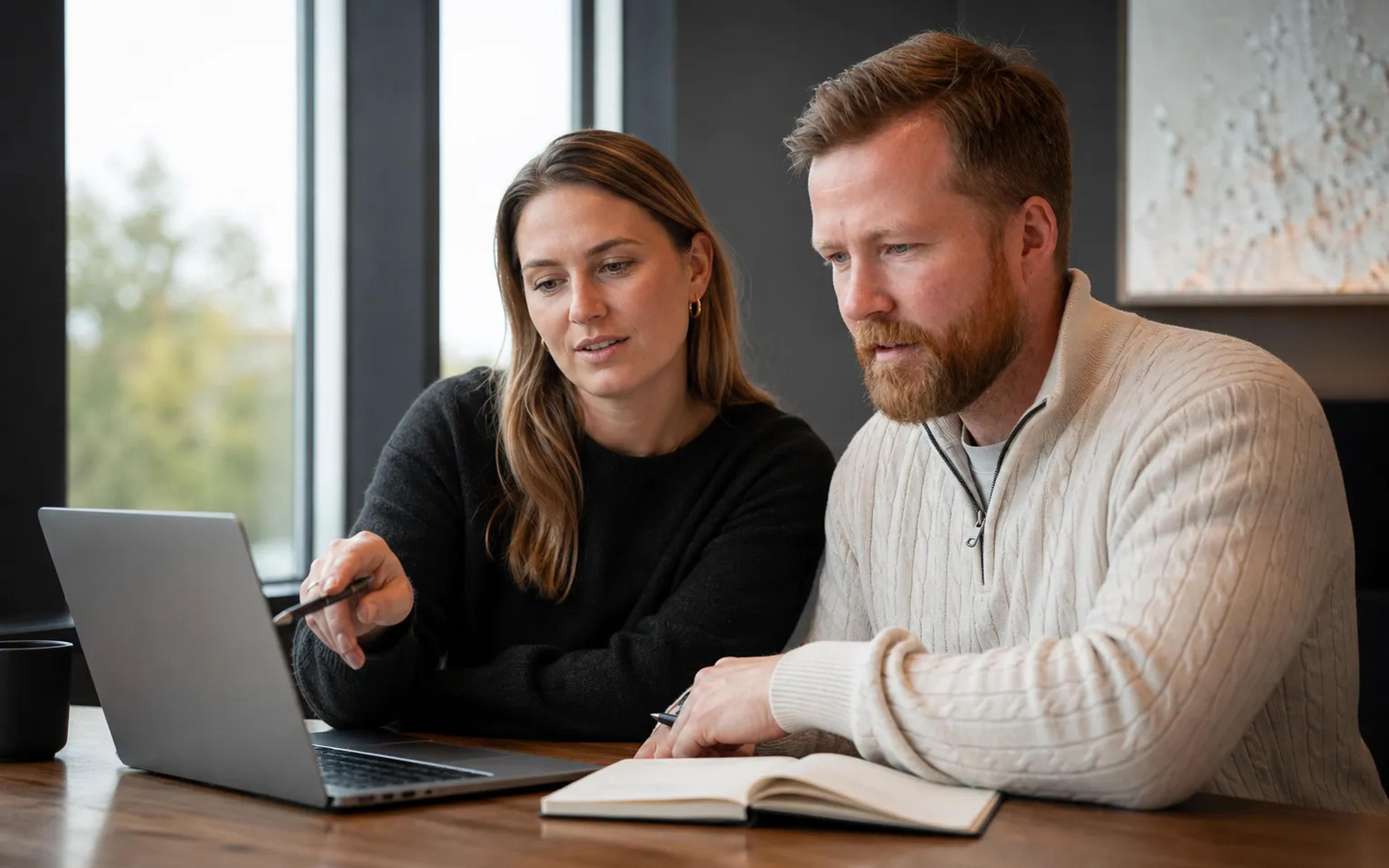 To personer vurderer annonsebudsjett og kampanjer på en bærbar PC.