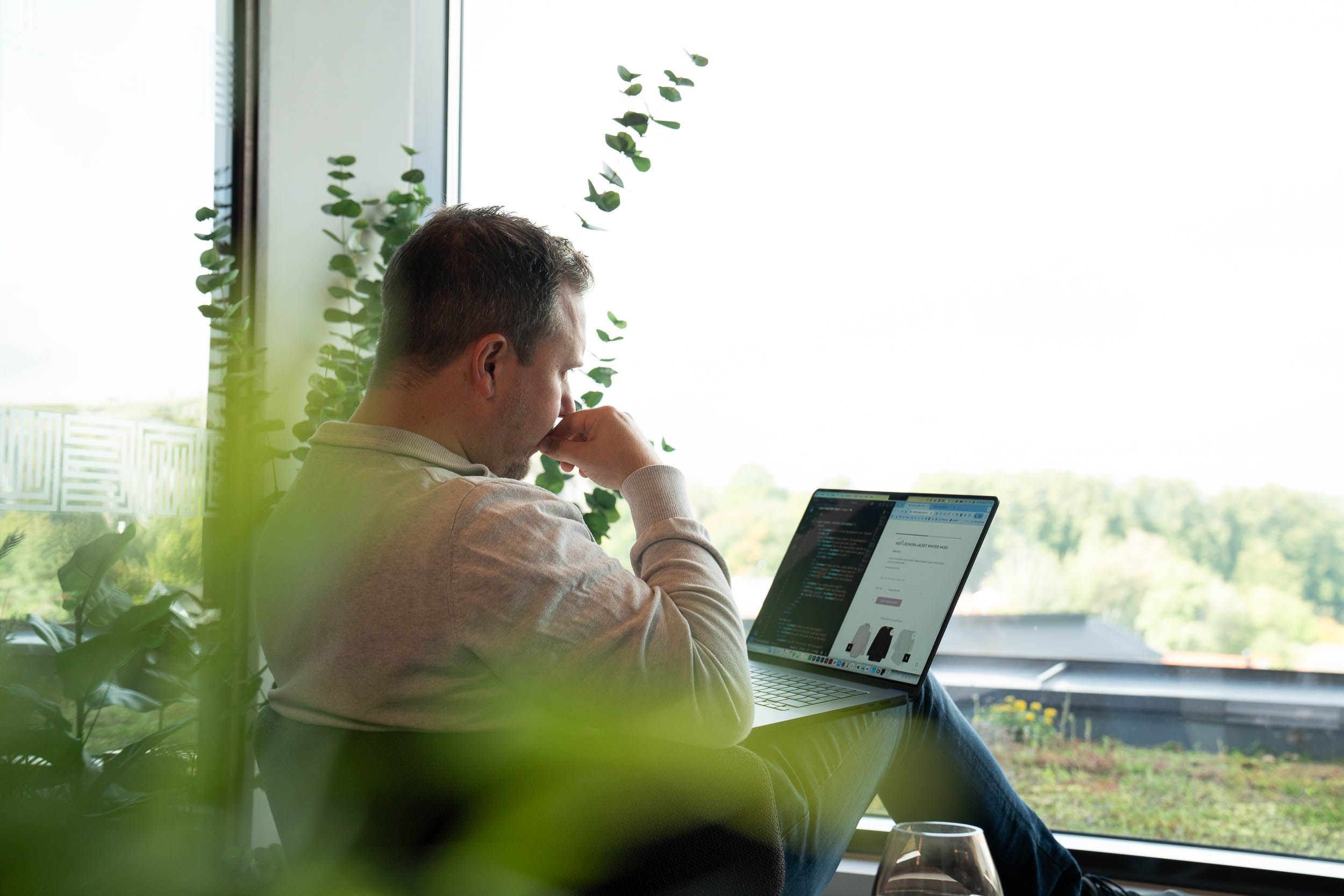 Utvikler setter opp integrasjon mellom kassesystem og nettbutikk på laptop, med kode og produktside på skjermen