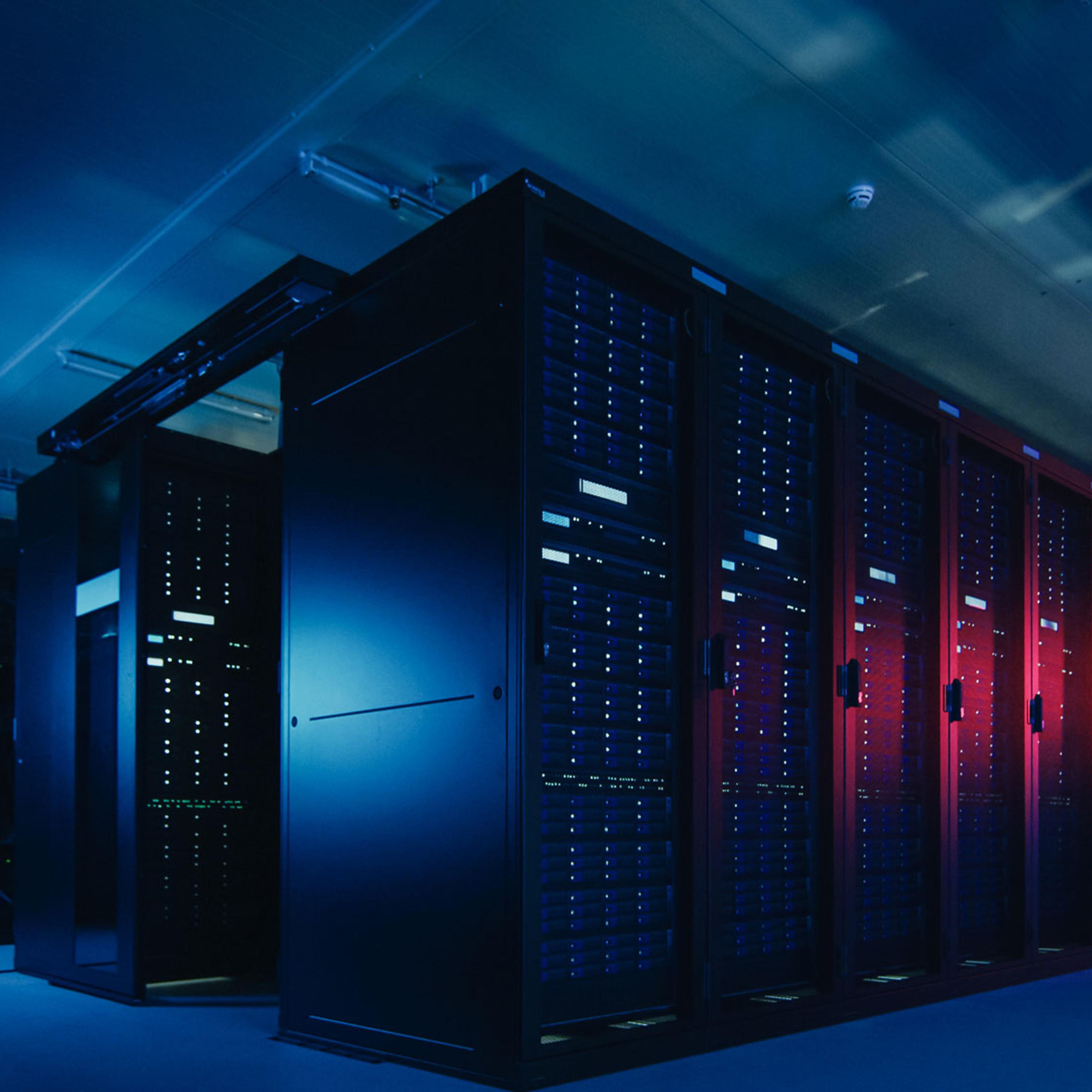 Serverrack med blå og røde LED-lys i moderne datakammer, illustrerer skyinfrastruktur og digital teknologi.